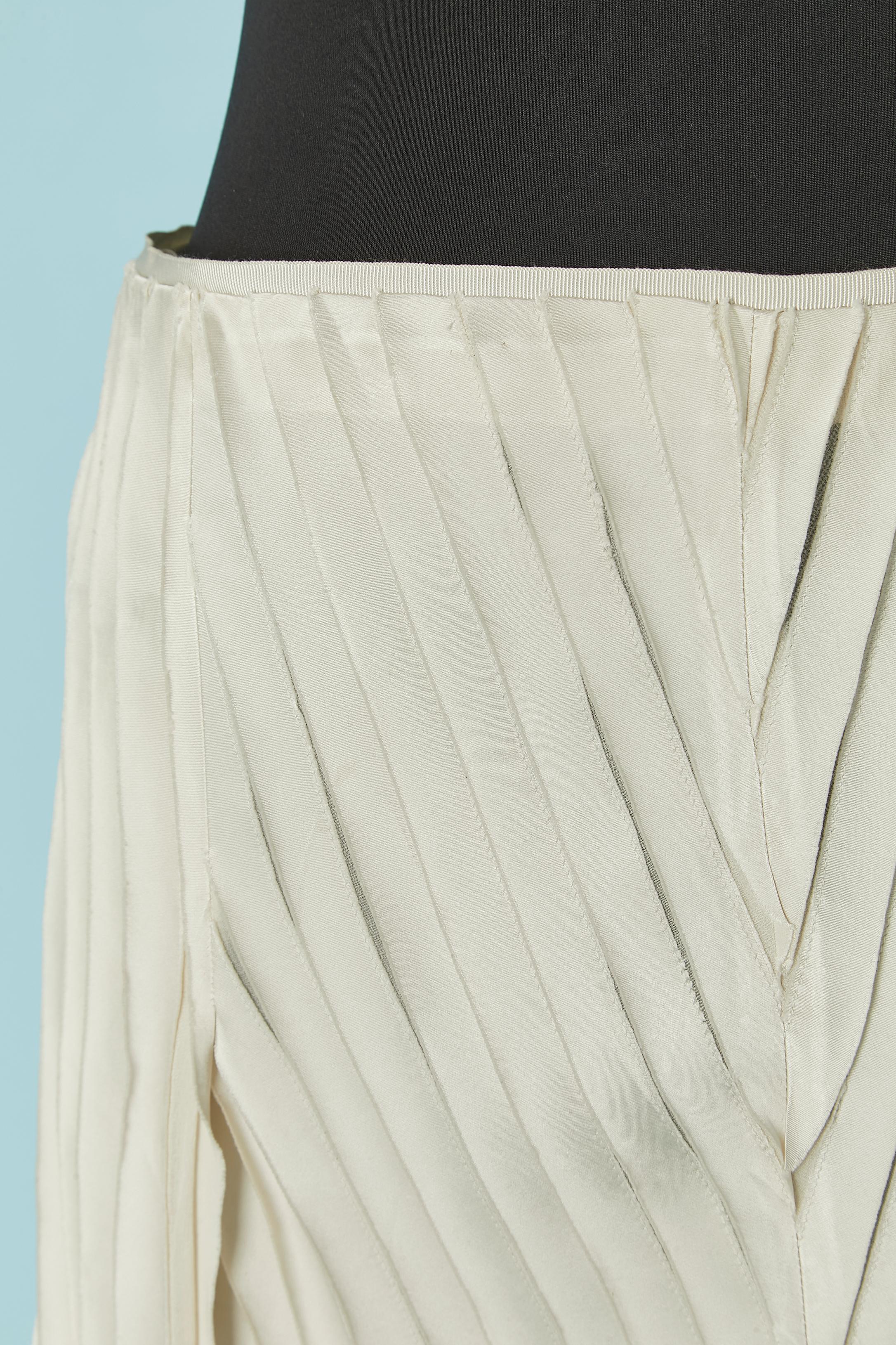 Gonna asimmetrica con nastri avorio su una base di chiffon di seta. Composizione tessuto Fabrice: 74% rayon, 26% seta. Vita in gros-grain. Chiusura con zip invisibile al centro della schiena con gancio e occhiello. Bordo inferiore grezzo. 
Lunghezza