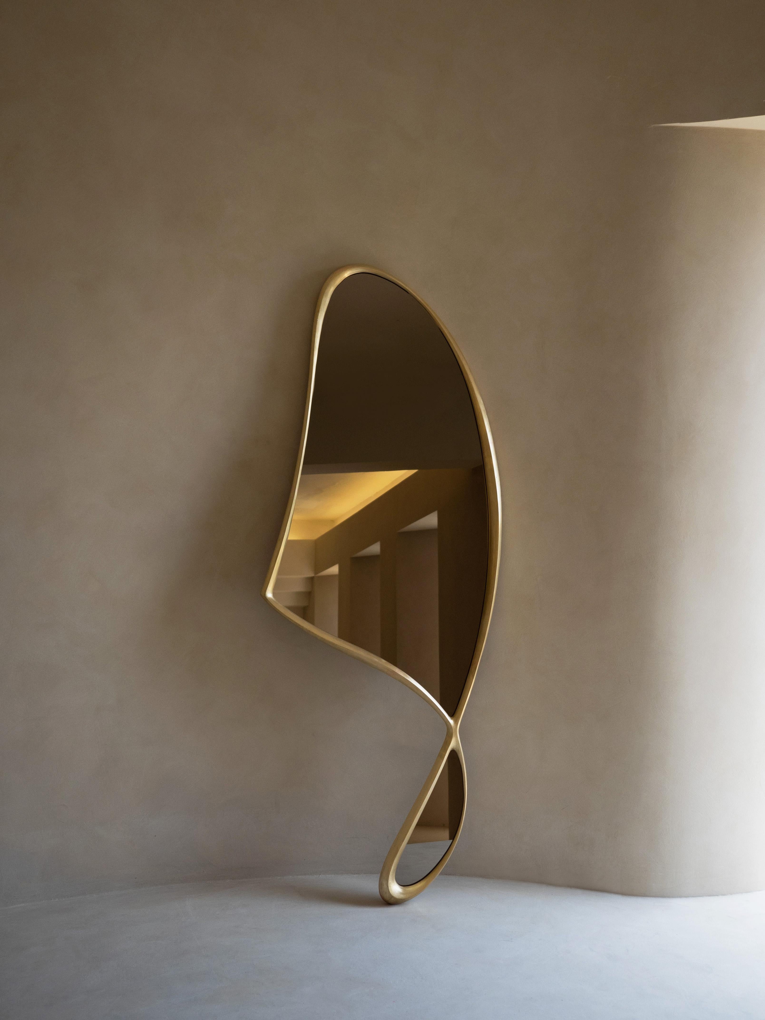 Momentum Mirror II by Soo Joo is a full-body statement mirror in cast bronze. It has a unique and timeless asymmetric form. Its undulating frame is meticulously sculpted in wood with a rasp tool, before being cast in metal. Its timeless form has an