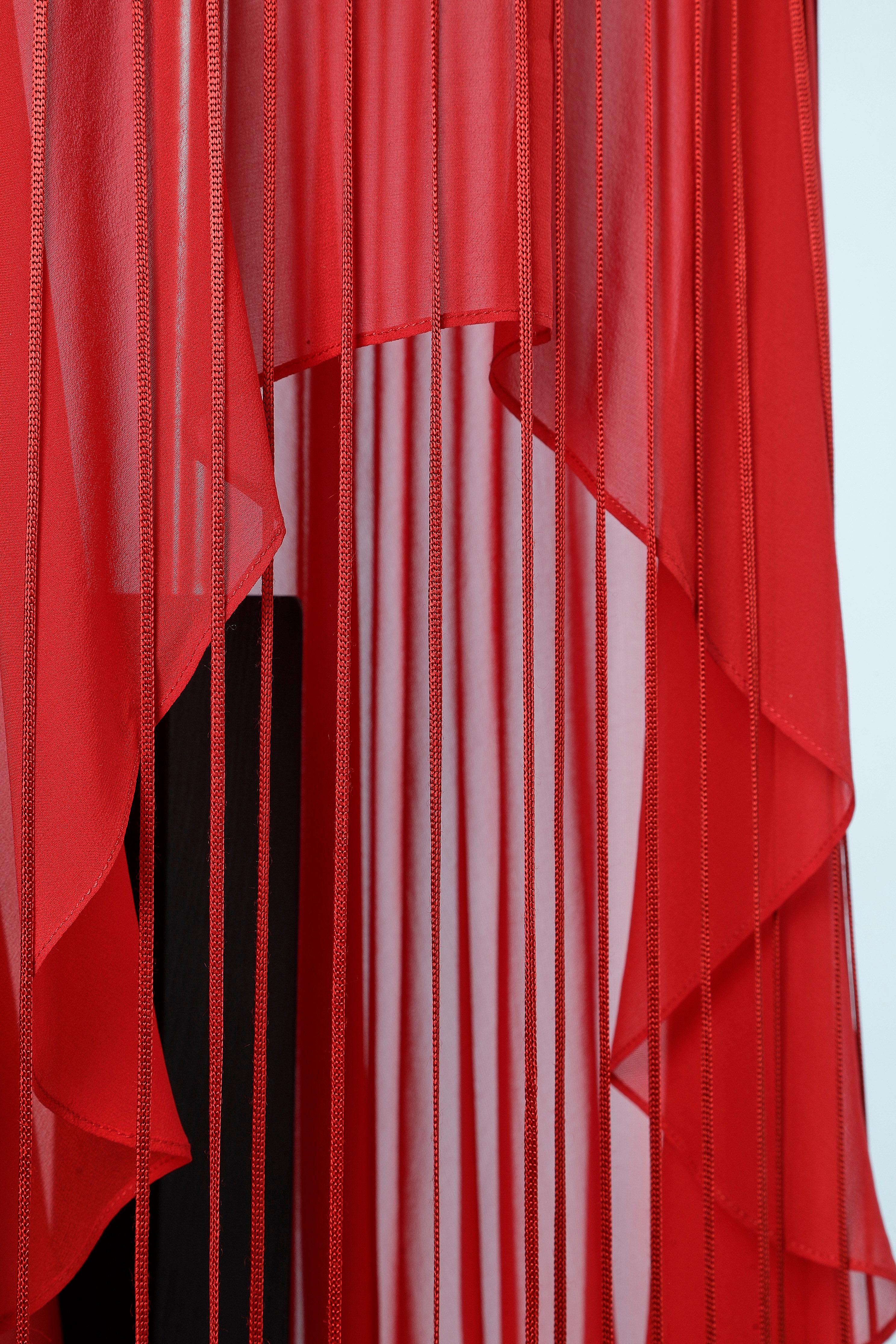 Asymmetrical silk red evening dress with ribbons appliqué. 
Invisible zip on the left side. 
