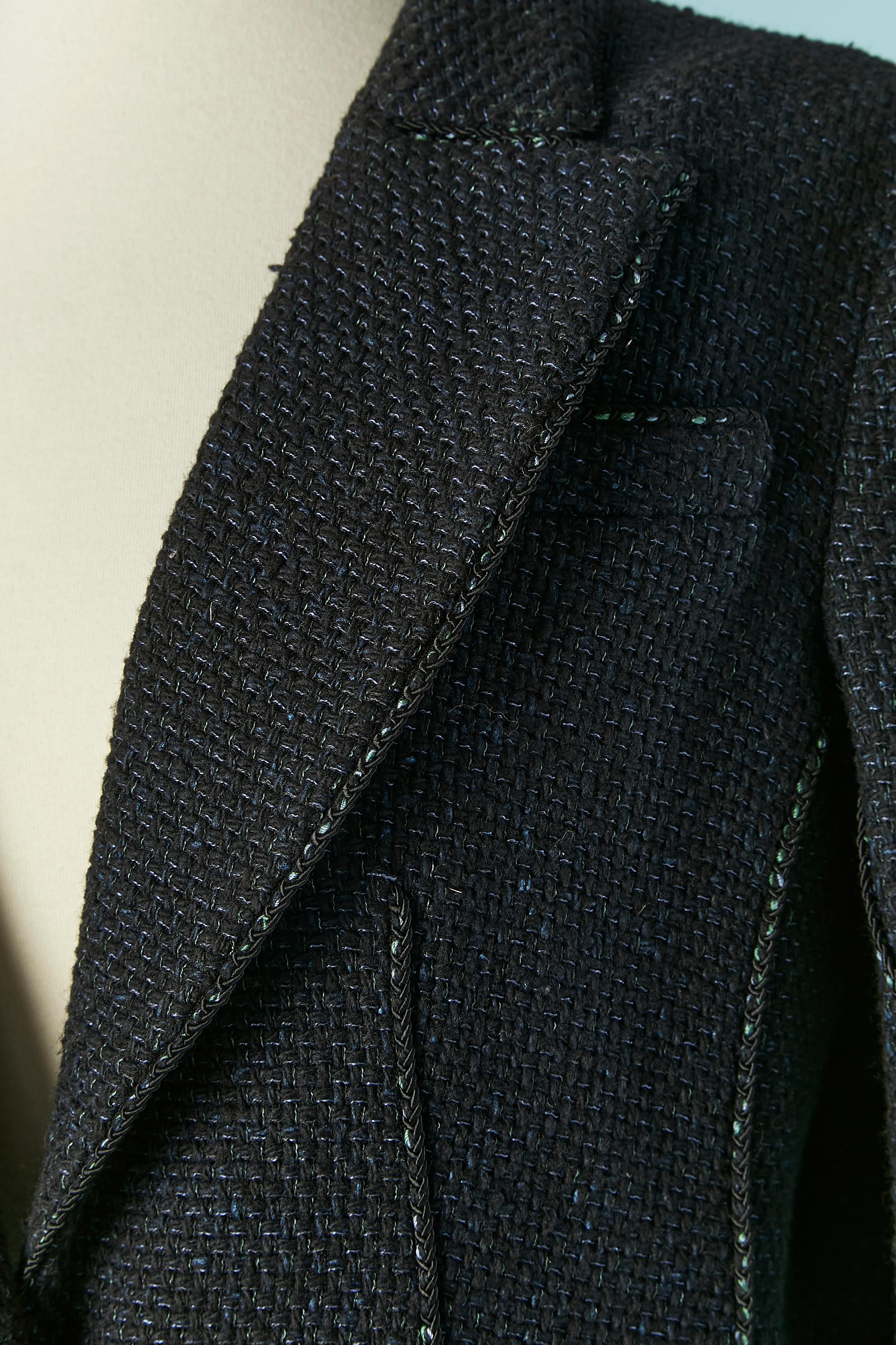 Veste en tweed à boutonnage unique asymétrique. Composition du tissu principal : 86% laine, 10% nylon, 4% polyester. 
Doublure en soie de marque. Une poche poitrine.
Fermeture par un bouton de marque sur le milieu du devant et sur les poignets.