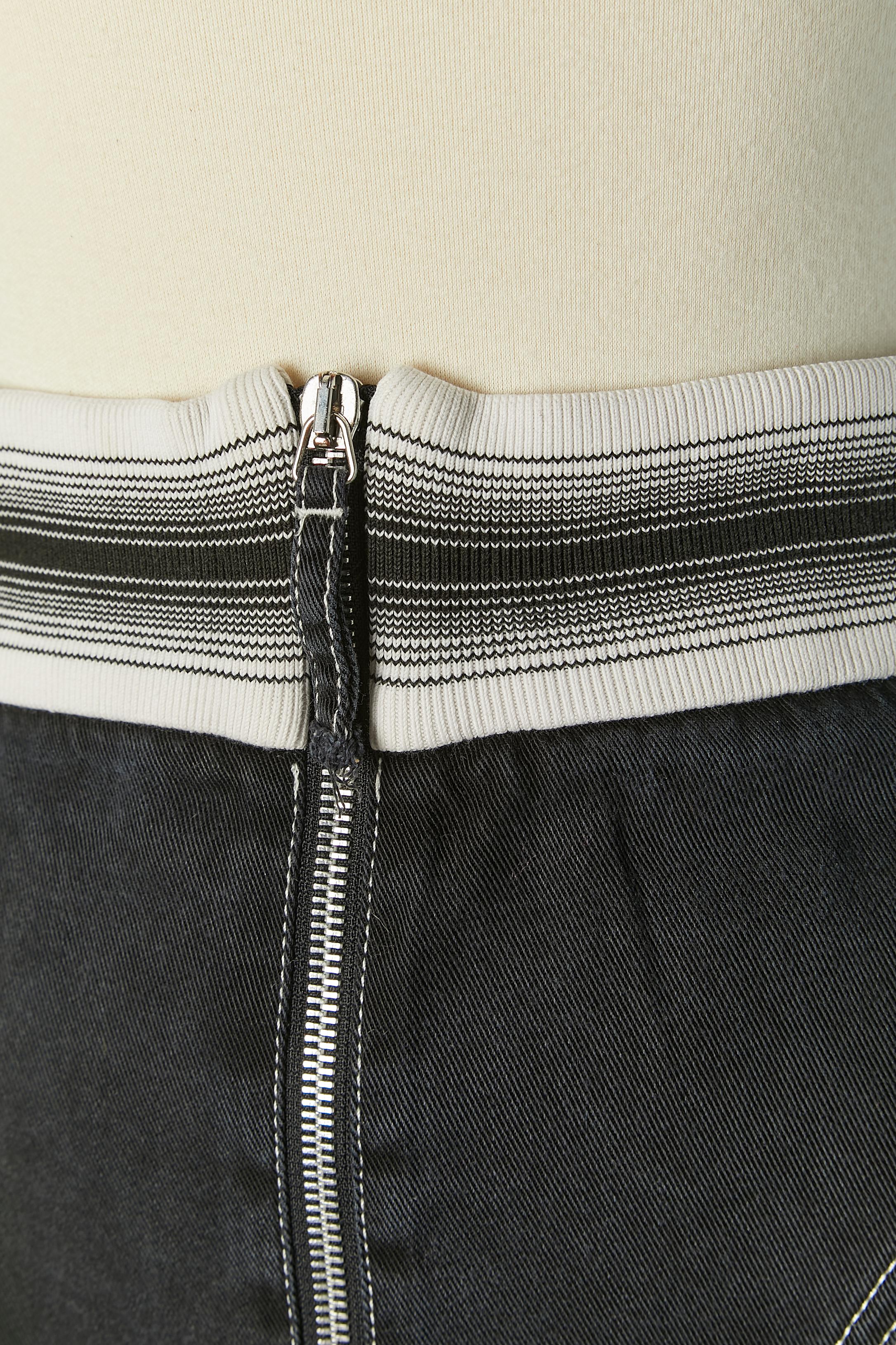 Jupe asymétrique avec empiècement en côtes rayées. 
Composition du tissu principal : 100% Tencel 
Fermeture à glissière sur le milieu du devant. 
TAILLE 44 (It) 40 (Fr) 