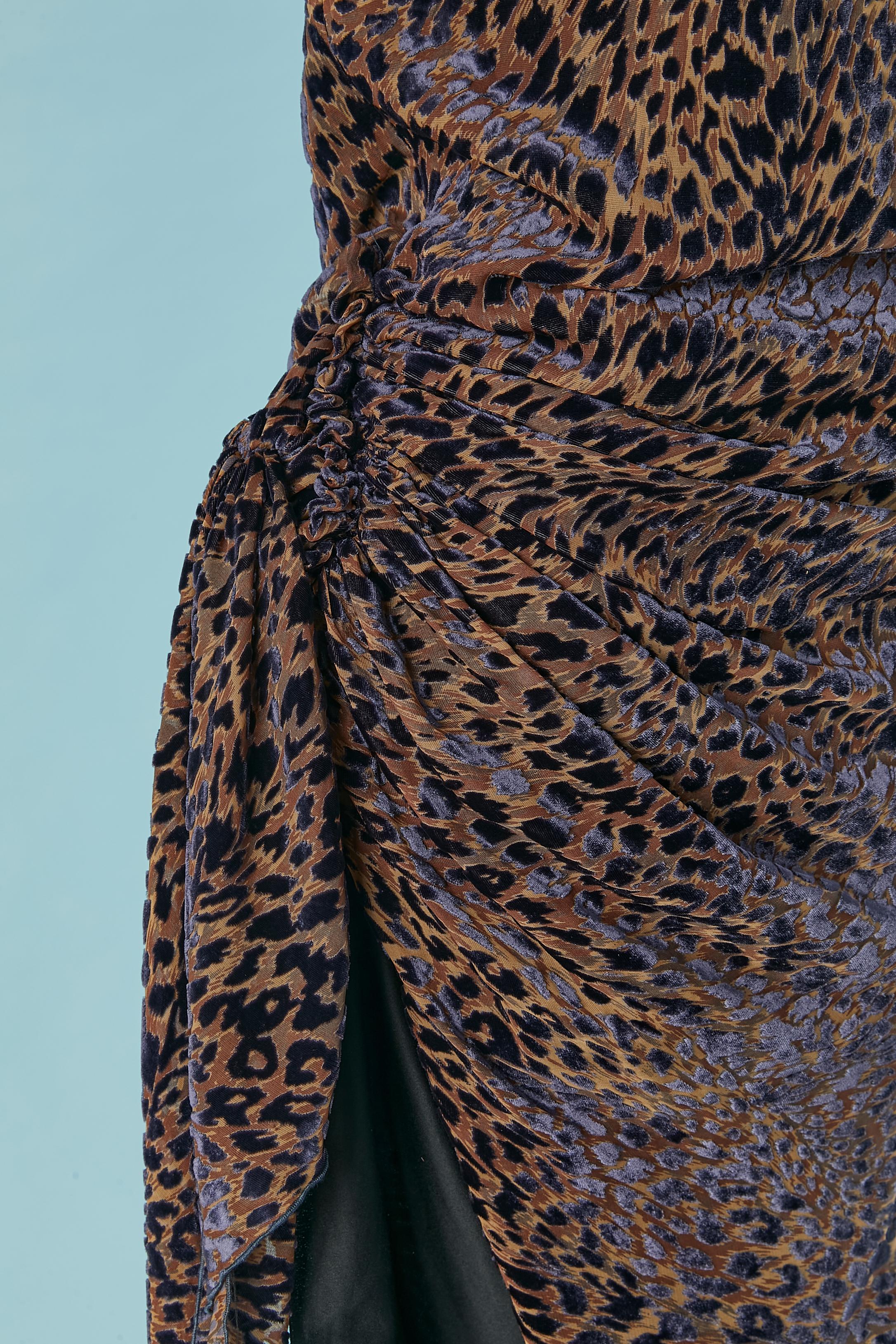 Asymmetrisches Abendkleid aus Samt mit Tiermuster. Zusammensetzung des Hauptgewebes: 60% Viskose, 40% Seide. 
Futter aus Polyester. Unsichtbarer Reißverschluss auf der linken Seite + Haken & Ösen. Auf der linken Seite drapiert. 
GRÖSSE 38 / M 