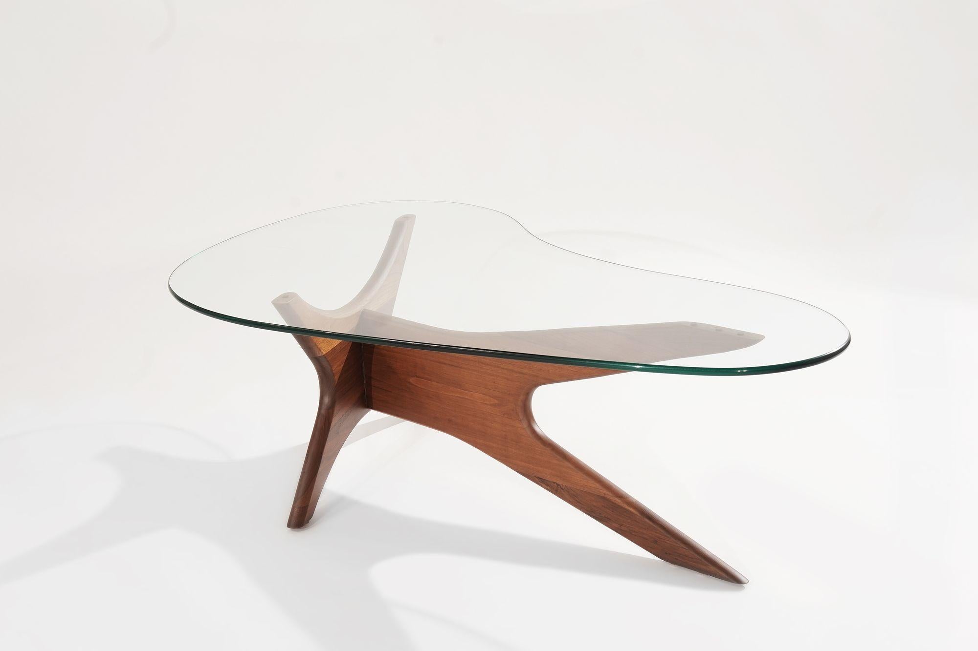 This striking coffee table, designed by Adrian Pearsall for Craft Associates in the 1950s, epitomizes mid-century modern elegance. The sculptural walnut base has been meticulously restored to highlight its organic, biomorphic design. Topped with a