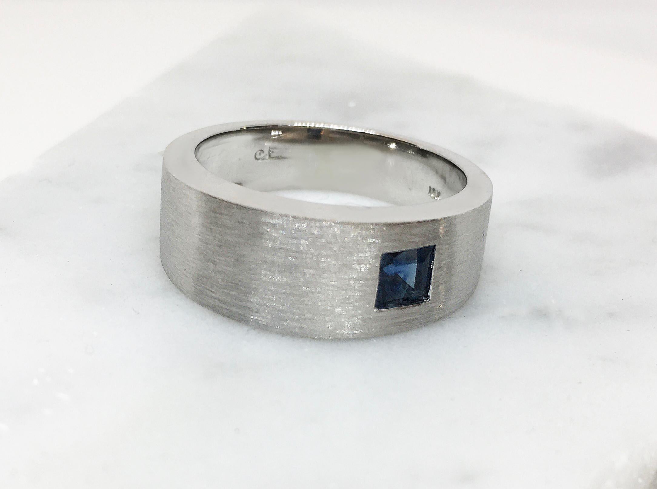 This large RADIUS ring is asymmetrically set with a brilliant square sapphire approximately .60pts.
An ideal choice for the unique man with an appreciation for design. Whether for a men's engagement ring or to show his style. Here in 18K white gold