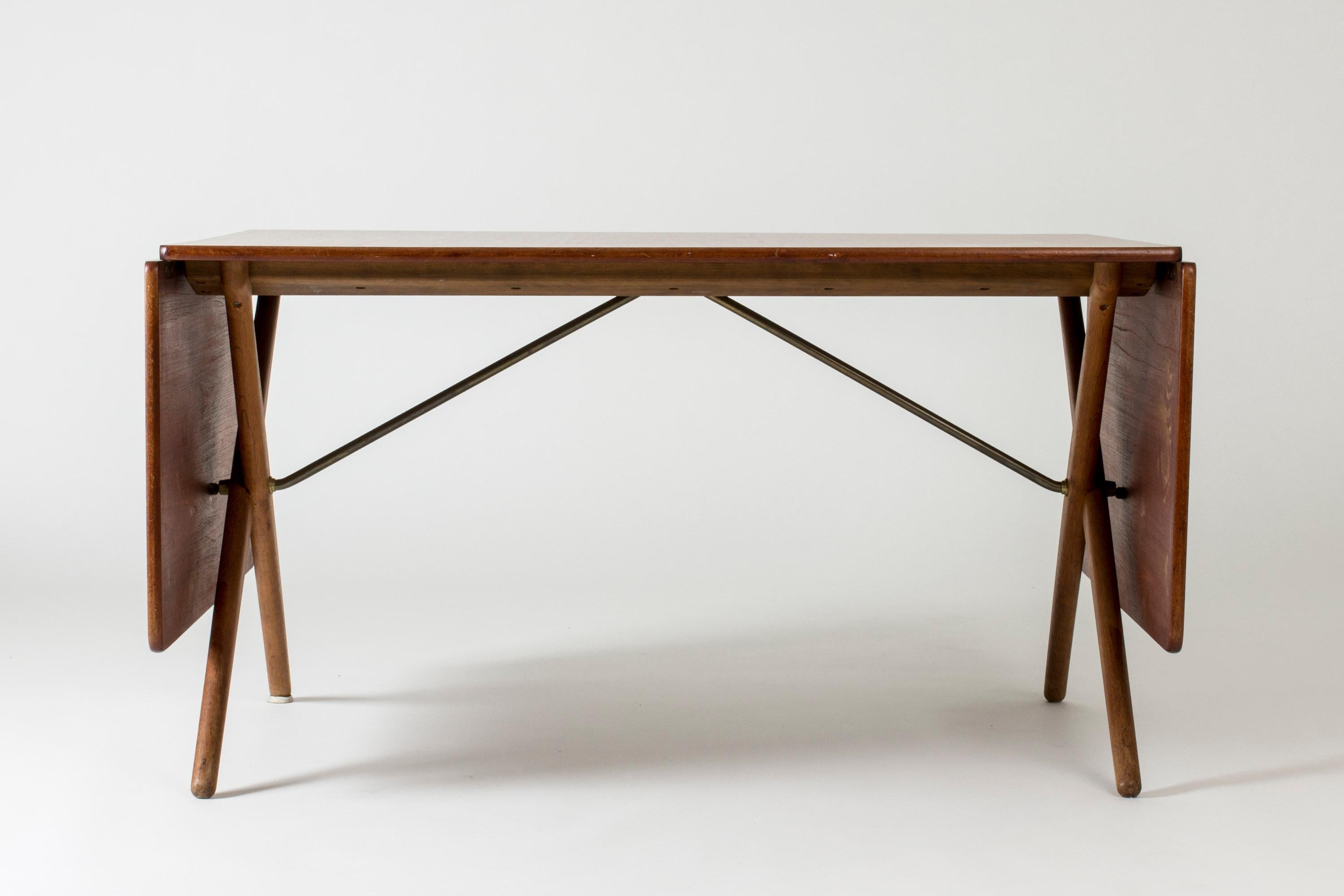 Cool “AT 303” dining table by Hans J. Wegner, with elegantly crossed legs. Made teak with oak legs. Drop leaves on each side make it a very versatile table.