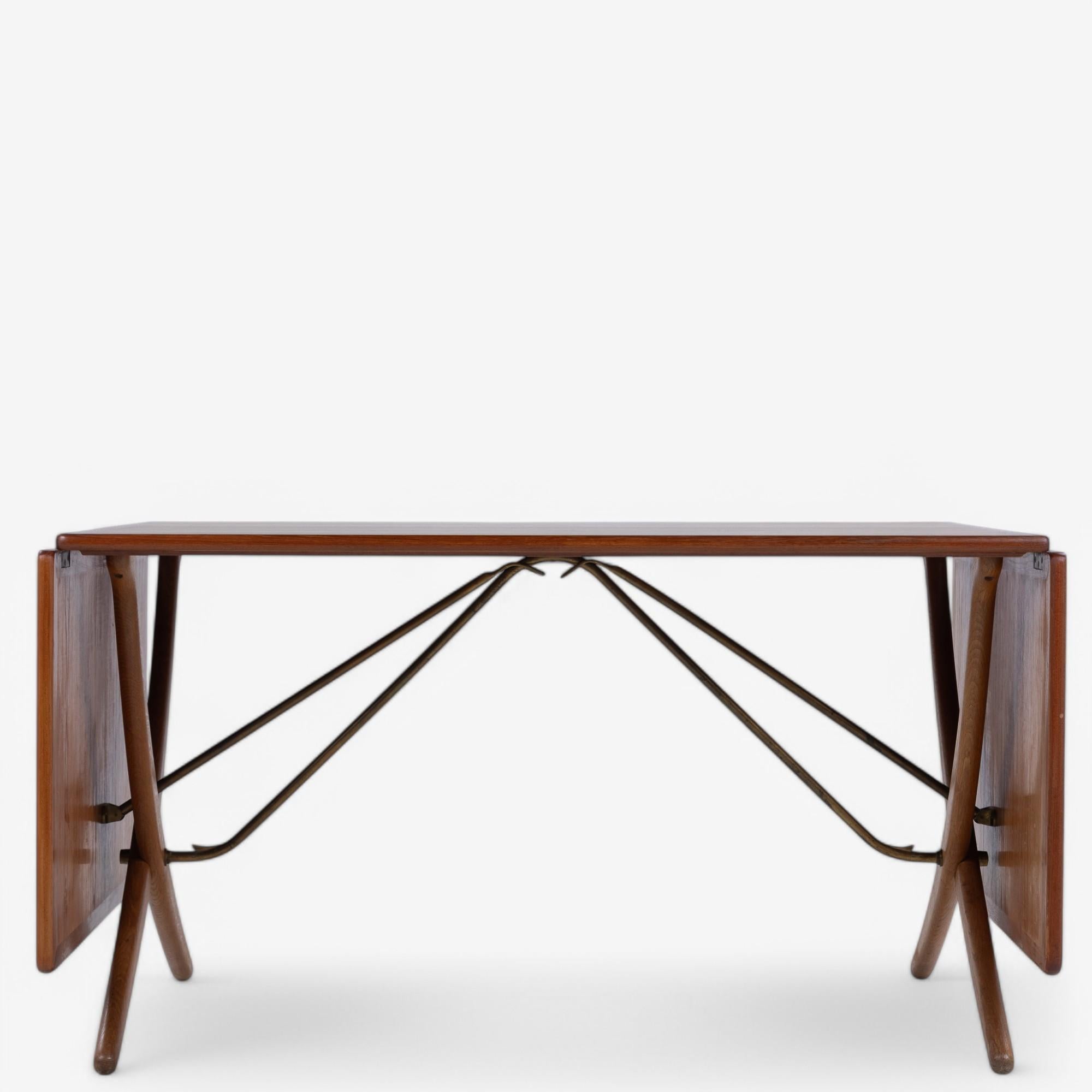 AT 304 - 'Sabre leg table' with frame in oak and top in teak. Flaps extend the length with 110 cm extra. Stamped from manufacturer Andreas Tuck. Designed by Hans J. Wegner.