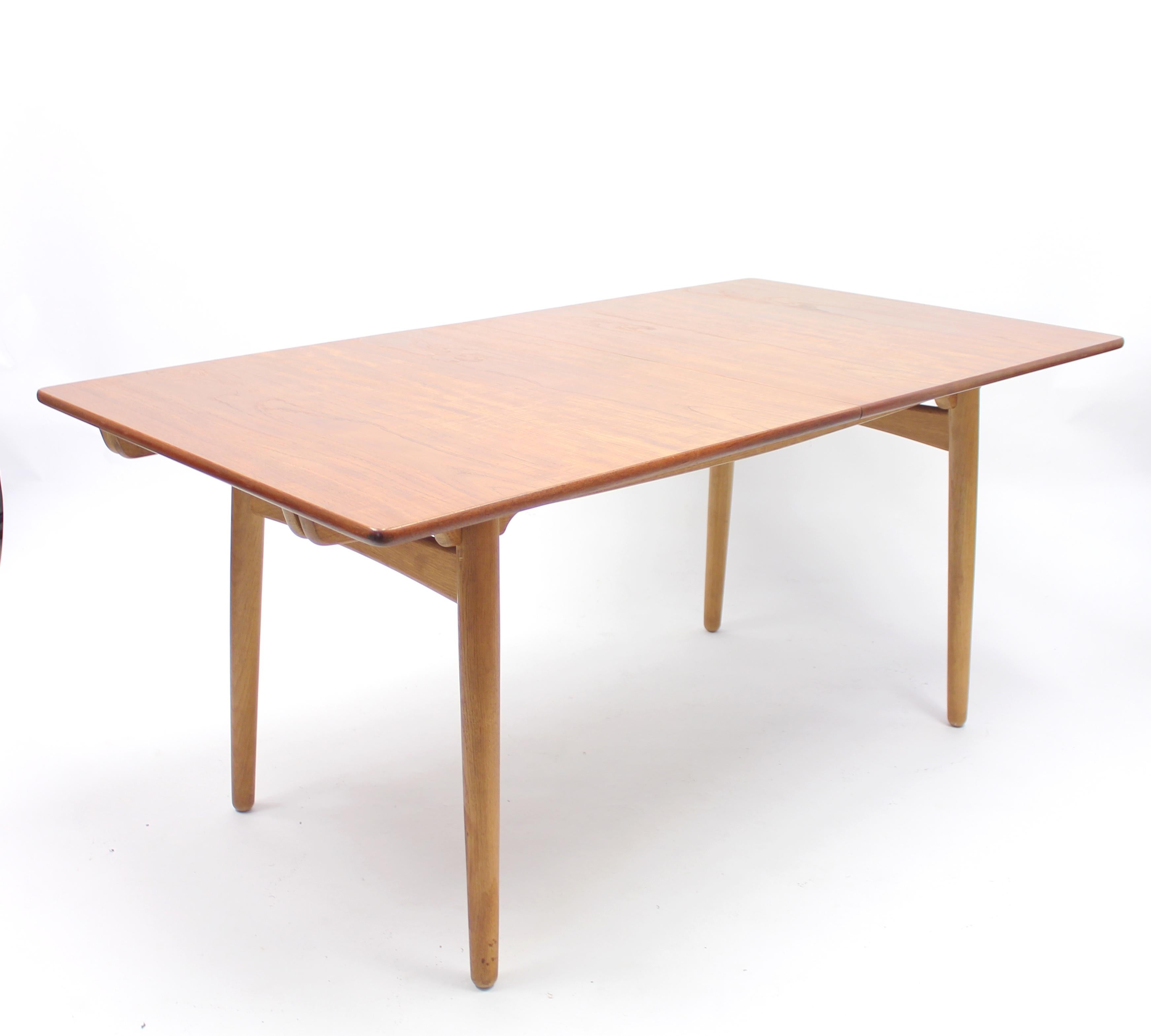 Dining table model AT310 design by Hans Wenger for Andreas Tuck in Denmark in the 1960s. Tabletop in teak veneer on an oak base. It also contains two original extra pine leafs under the tabletop. The extra leafs measures 40 cm each so maximum length