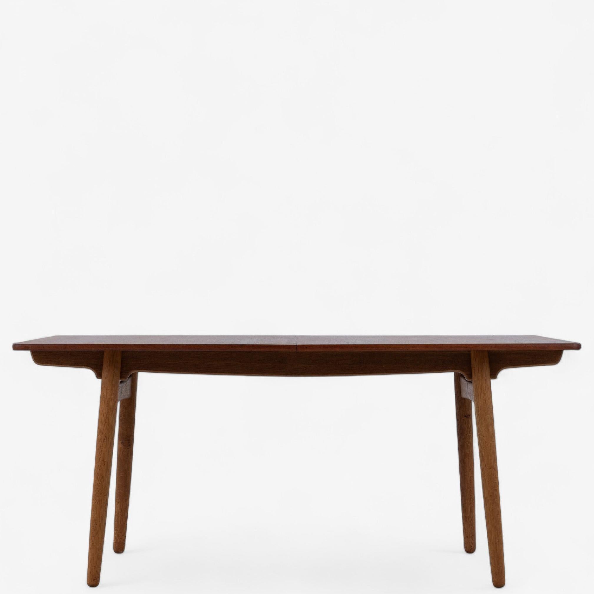 AT 310 - Dining table with oak frame and teak top with two extension leaves. Extensions leaves adds 40 cm each to the table length. Stamped by cabinetmaker Andreas Tuck and designed by Hans J. Wegner.