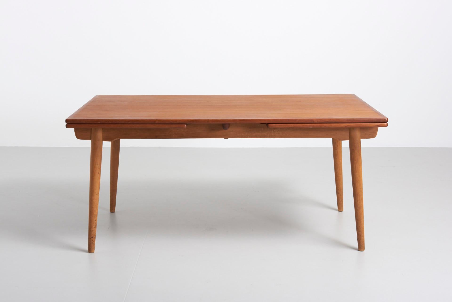 A rare large edition of model AT 312. A dining table designed by Hans J. Wegner, produced by Andreas Tuck in Denmark. Features 2 extension leaves of 60cm each. Legs in solid oak, table top in teak. In perfect condition.