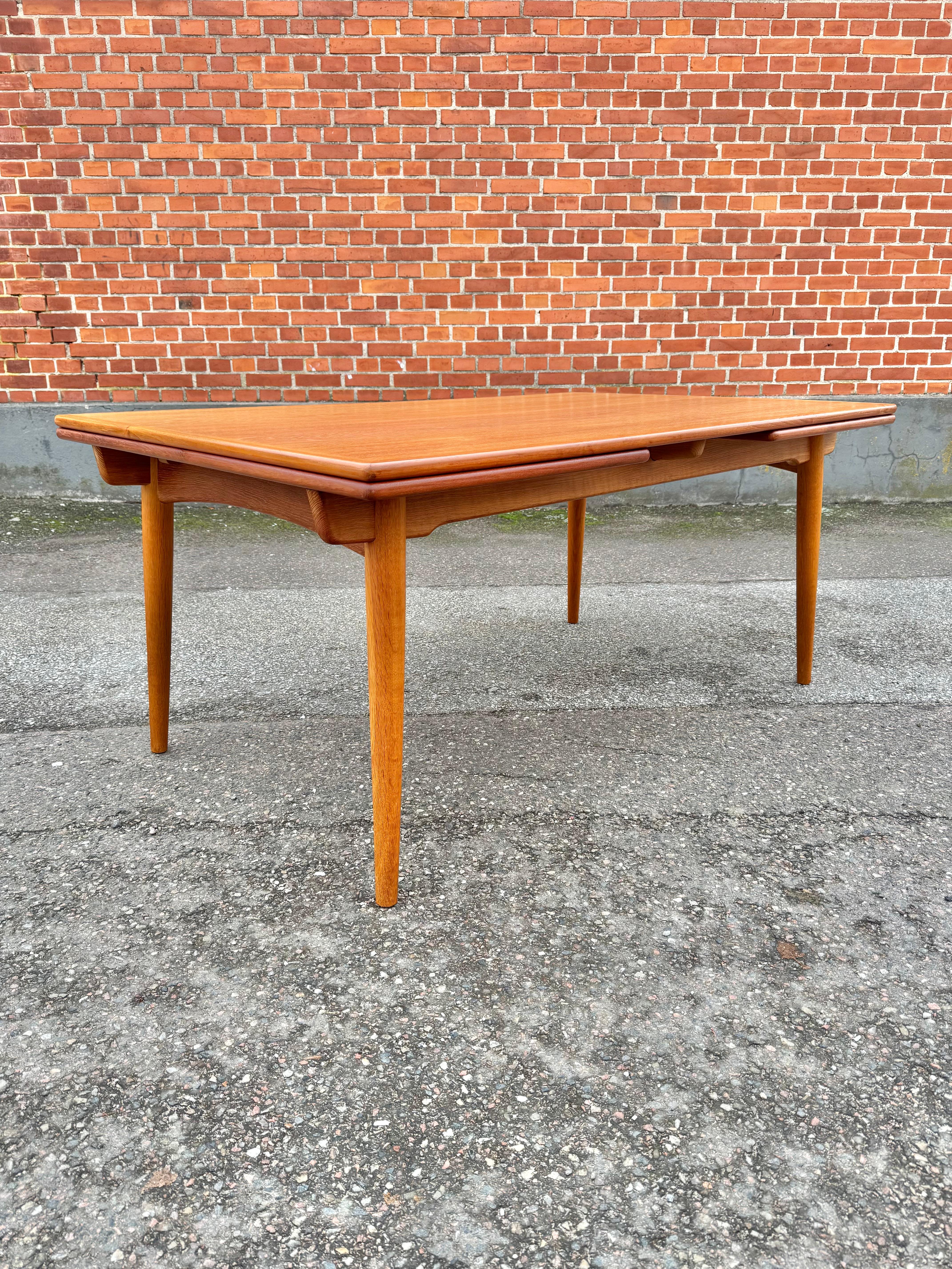 Dining table model AT-312 designed by Hans Wegner for Andreas Tuck, Denmark, 1960s. Made in oak, the table boasts two pull-out leaves which hide under the top and integrate beautifully with it when the table is not extended; this is not only a