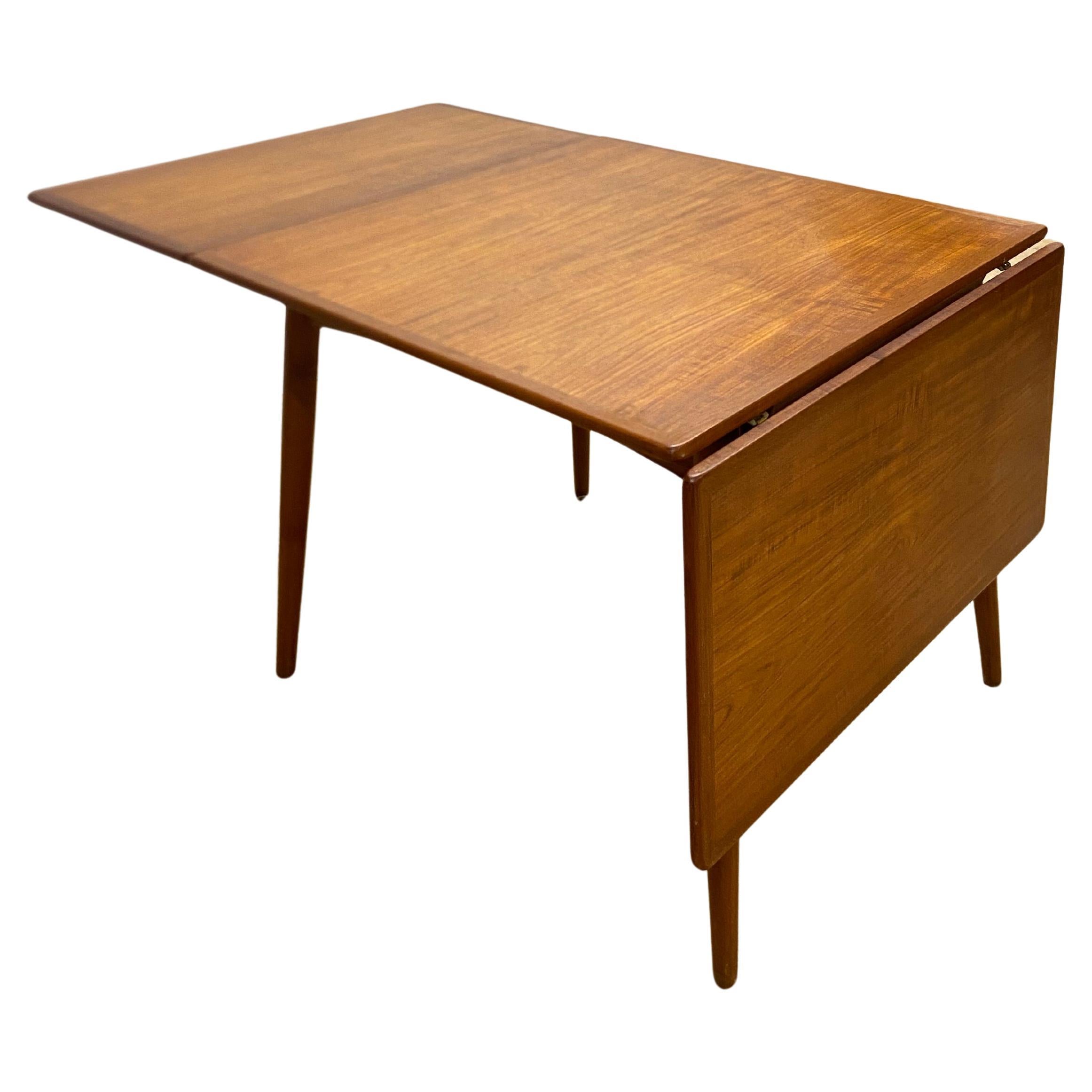 Designed by Hans Wegner, one of the leading figures of the danish modern movement in the mid-20th century, this table, created in 1956, boasts perfectly balanced proportions. The tabletop and its two drop leaves are elegantly framed by a teak