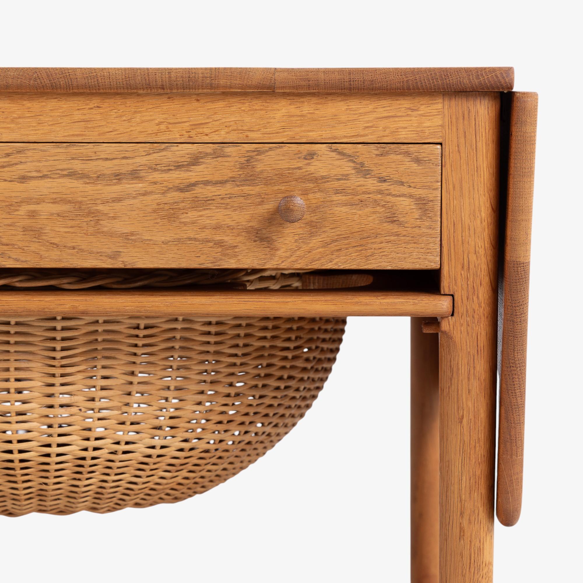 AT 33 - Table de couture en chêne avec deux abattants, tiroir et panier en osier. Les rabats permettent d'obtenir une largeur supplémentaire de 51 cm. Conçu par Hans J. Wegner et fabriqué par Andreas Tuck.