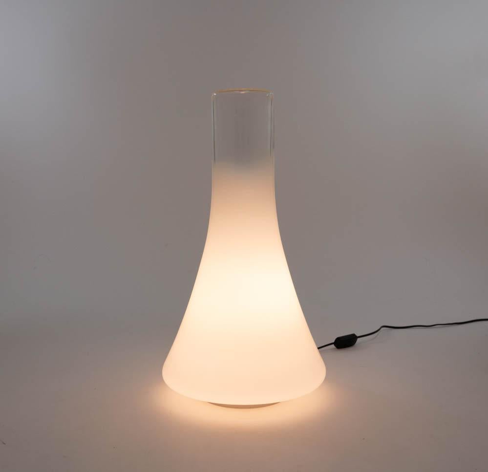 En la lámpara de sobremesa o de pie Iovis, diseñada por Angelo Mangiarotti y fabricada por Gloria en la década de 1990.

El modelo consta de una gran parte de cristal blanco; la parte superior es transparente. La parte superior está acabada con un