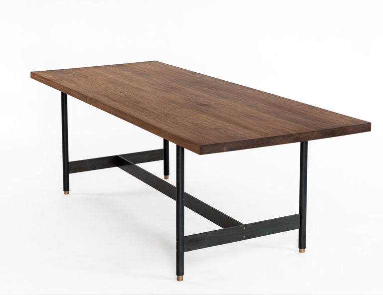 The AT10 is a handmade solid walnut dining table with a blackened steel base and bronze accents. It’s perfect for the dining room, and its bold clean lines translate to any scale, allowing for applications such as conference or work tables for the