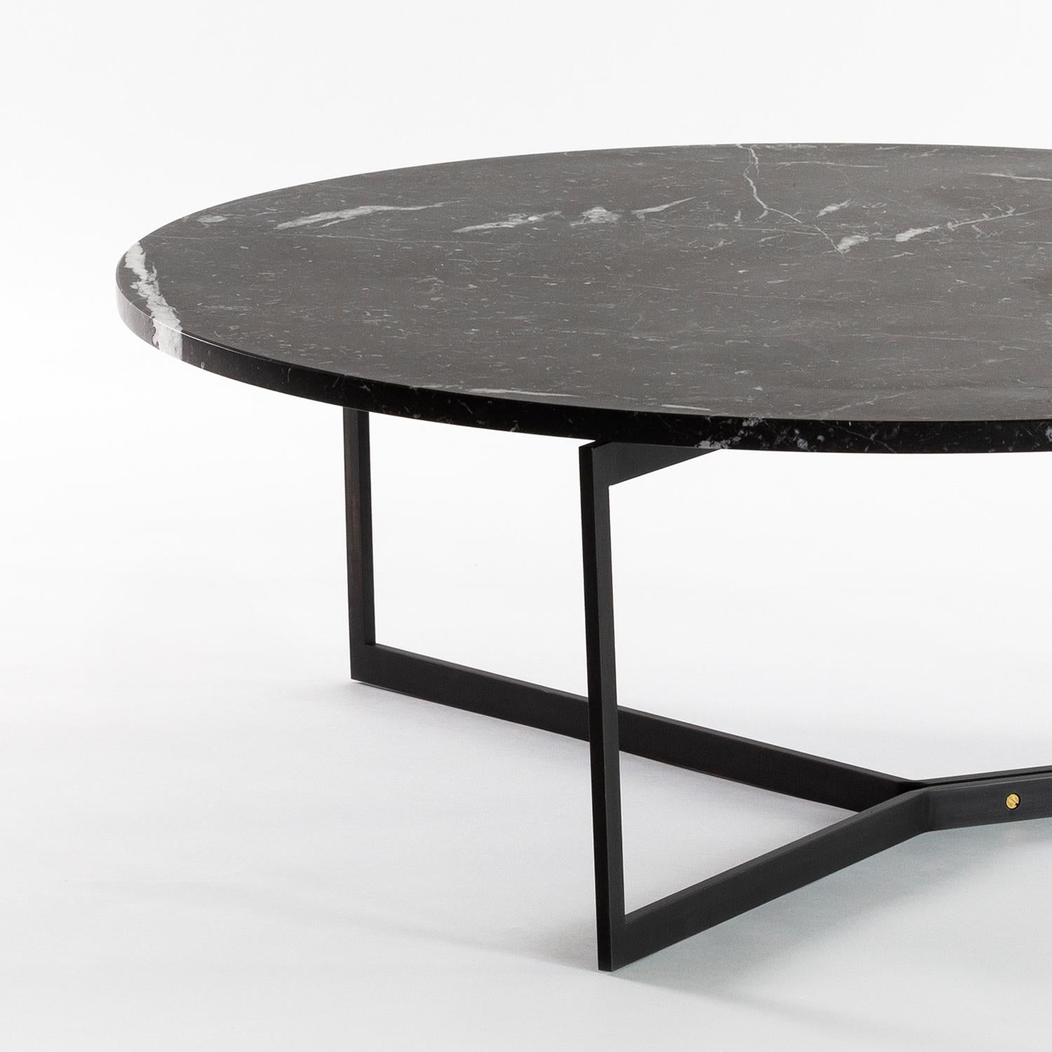 AT14 est une table basse fabriquée à la main avec une base métallique élégante et un plateau en marbre poli ou en bois dur.

Représenté en marbre Nero Marquina et en acier laminé à froid noirci avec des accents de bronze. 

Dimensions : 36