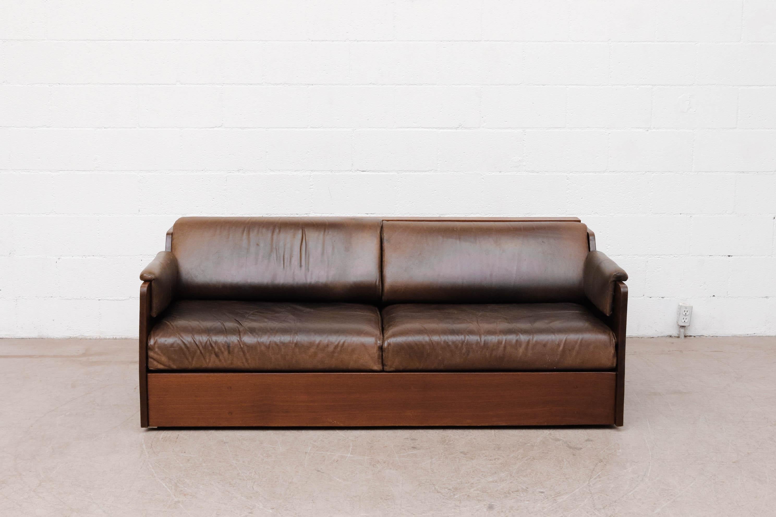 Ate van Apeldoorn Solid Iroko wood loveseat. Iroko wood is also known as African teak. It is an extremely heavy solid wood sofa. The loveseat has leather cushions and headrest cushions can velcro off. European outlet built in. Frame and leather are