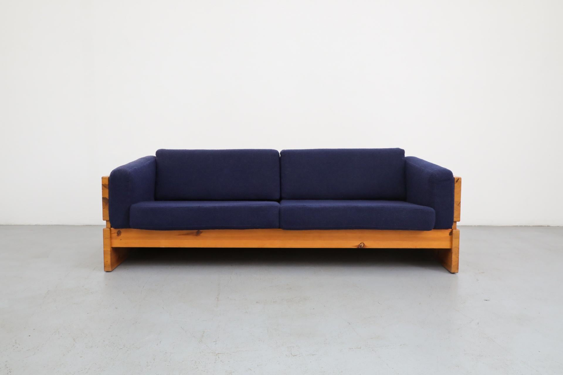 Ate van Apeldoorn style pine sofa with upholstered blue cushions. Visible staining and sun fading to the cushion (left arm, left back of pillow and side panel). In original condition with visible wear consistent with its age and use. Matching