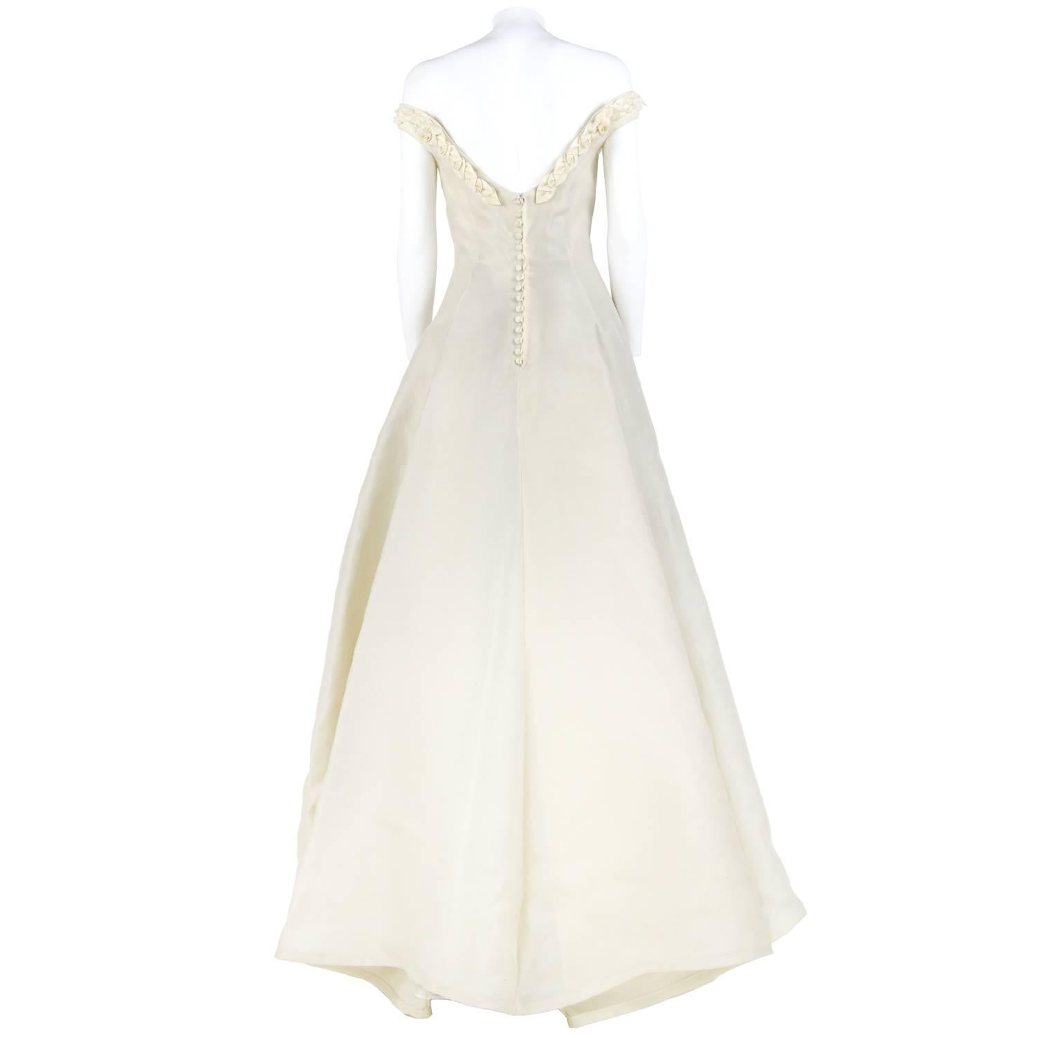 Princess dress Atelier Aimée Haute Couture Montenapoleone in ivory silk. It features a wide off-the-shoulders neckline decorated with silk roses, and a wide flared skirt. Buttons closure on the back. The item is vintage, it was produced in the 2000s