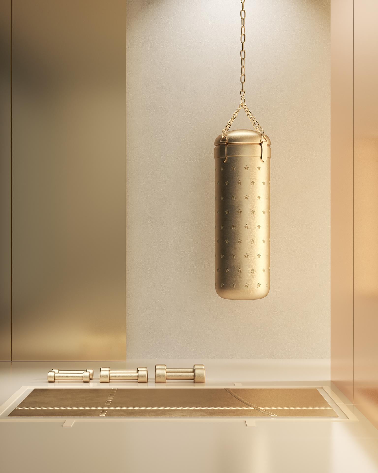 Boxing punch bag entirely upholstered in gold ecosustainable materials. The punching bag is entirely embroidered with stars in gold thread. 
KO is part of Body Building 2, the first eco-sustainable project presented by Atelier Biagetti; the project