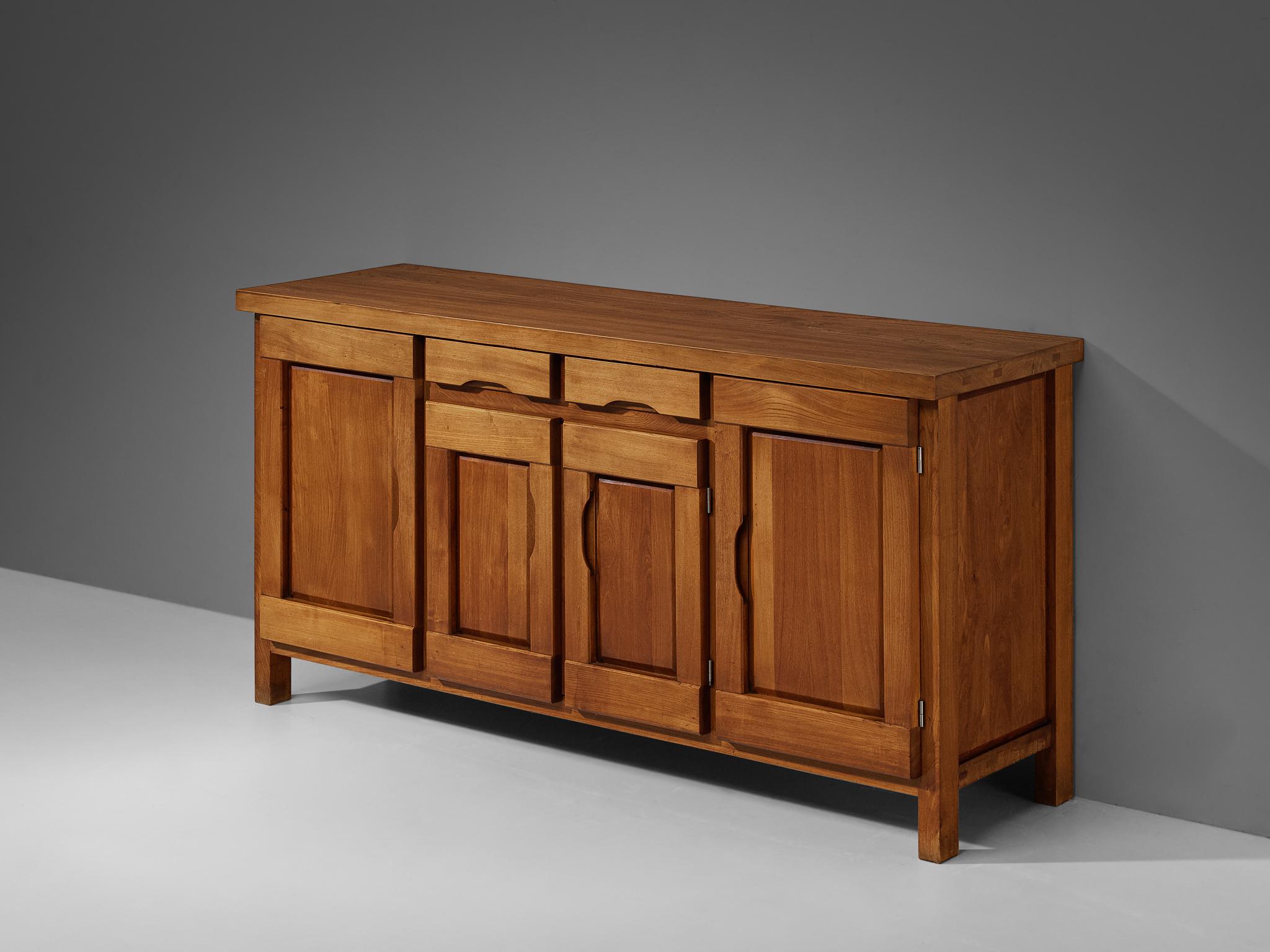 Atelier C. Demoyen sideboard, elm, France, 1970s

Gorgeous and naturalistic sideboard designed by Atelier C. Demoyen in the 1970s. Made in elm wood, this piece casts a stunning and rich atmosphere because of the use of this warm wood type. With