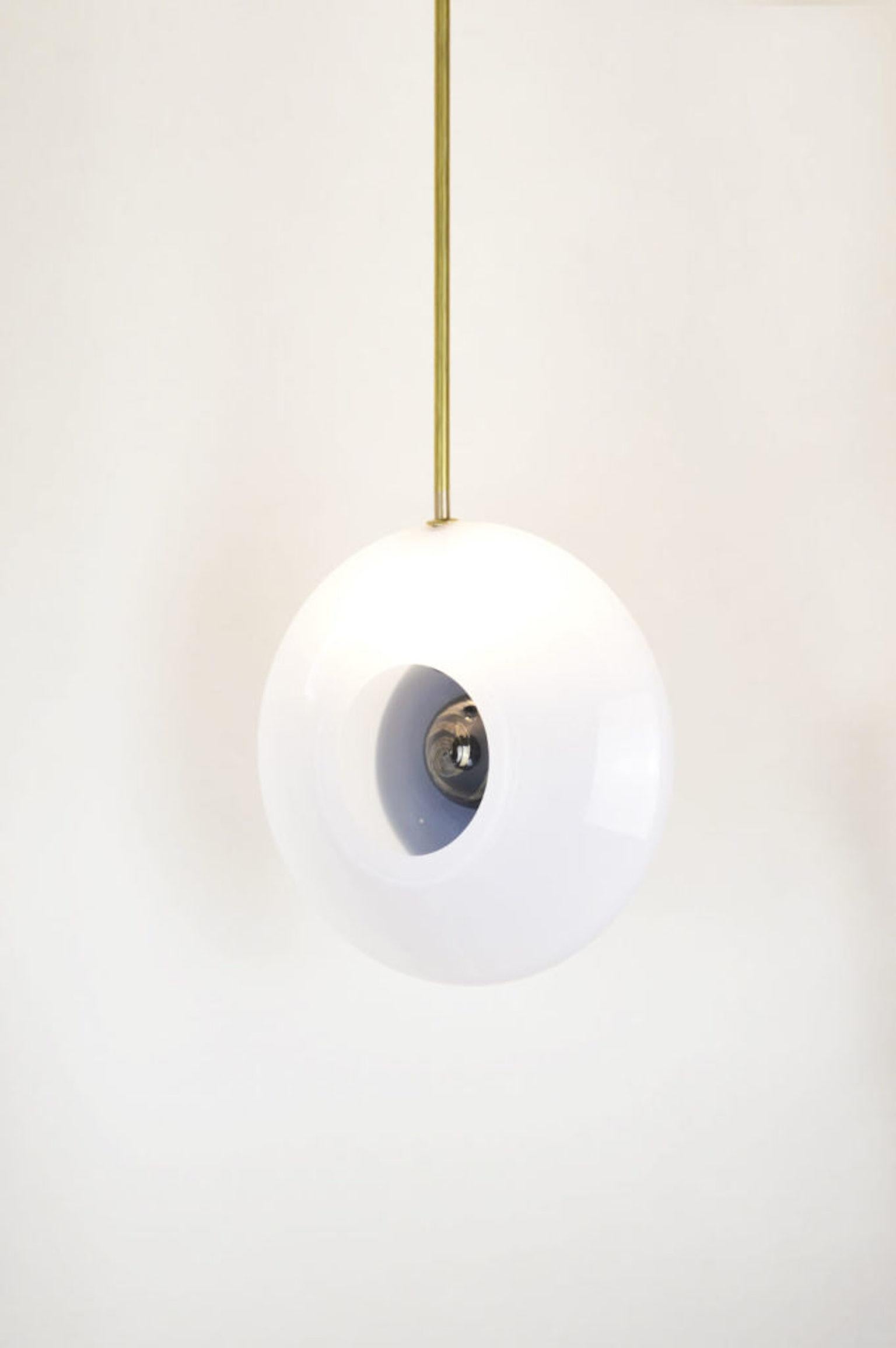 Pendant light conceptualized by Atelier George in 2020, and it corresponds to the Aube Collection.
This lighting piece is made of blown glass with two fundamental elements, the white ellipse shape from the outside, and a black heart shape from the