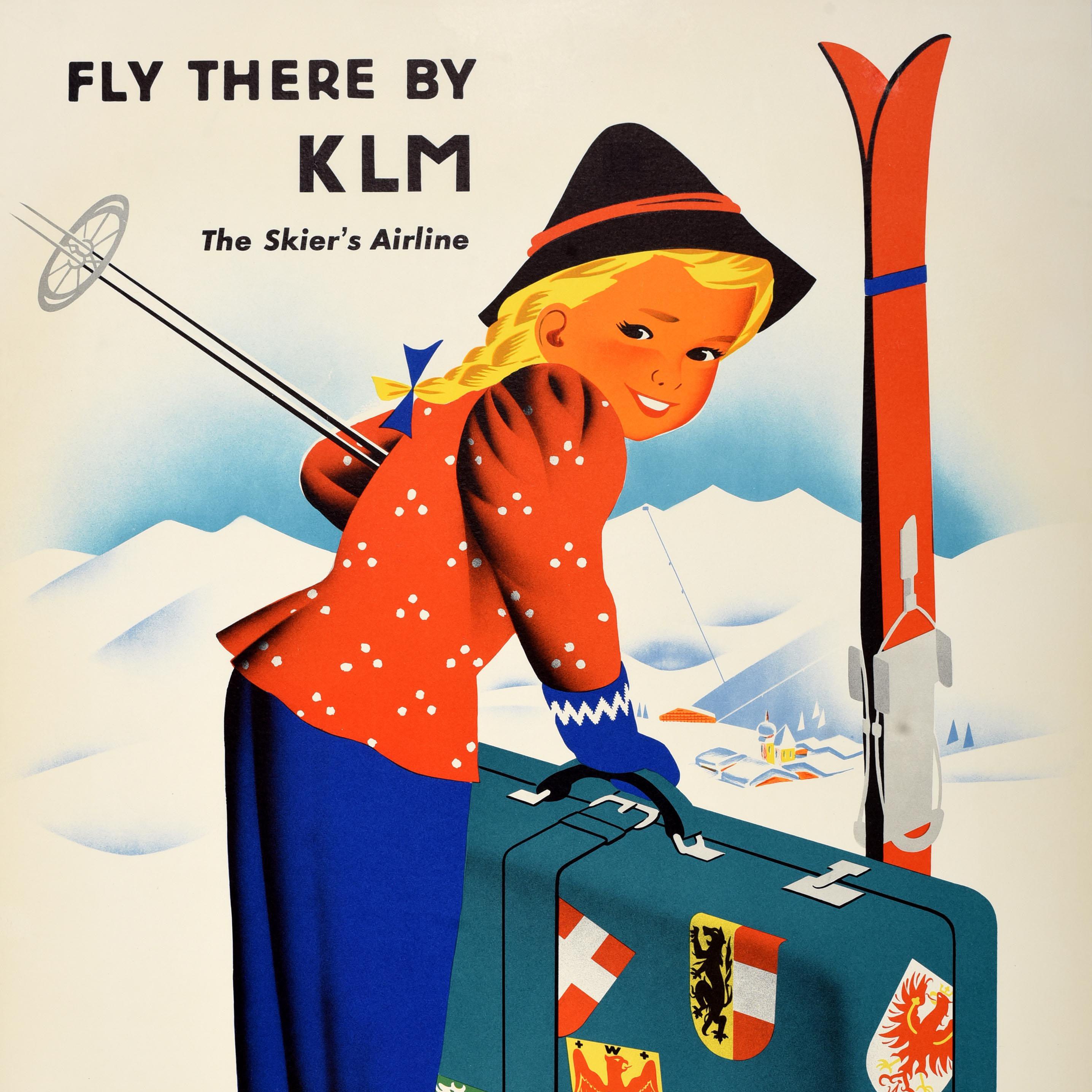 Original vintage ski travel poster - Winter in Austria Fly There by KLM The Skier's Airline - featuring an image of a smiling girl in a traditional hat holding ski poles with her skis next to a large suitcase covered in luggage labels showing the