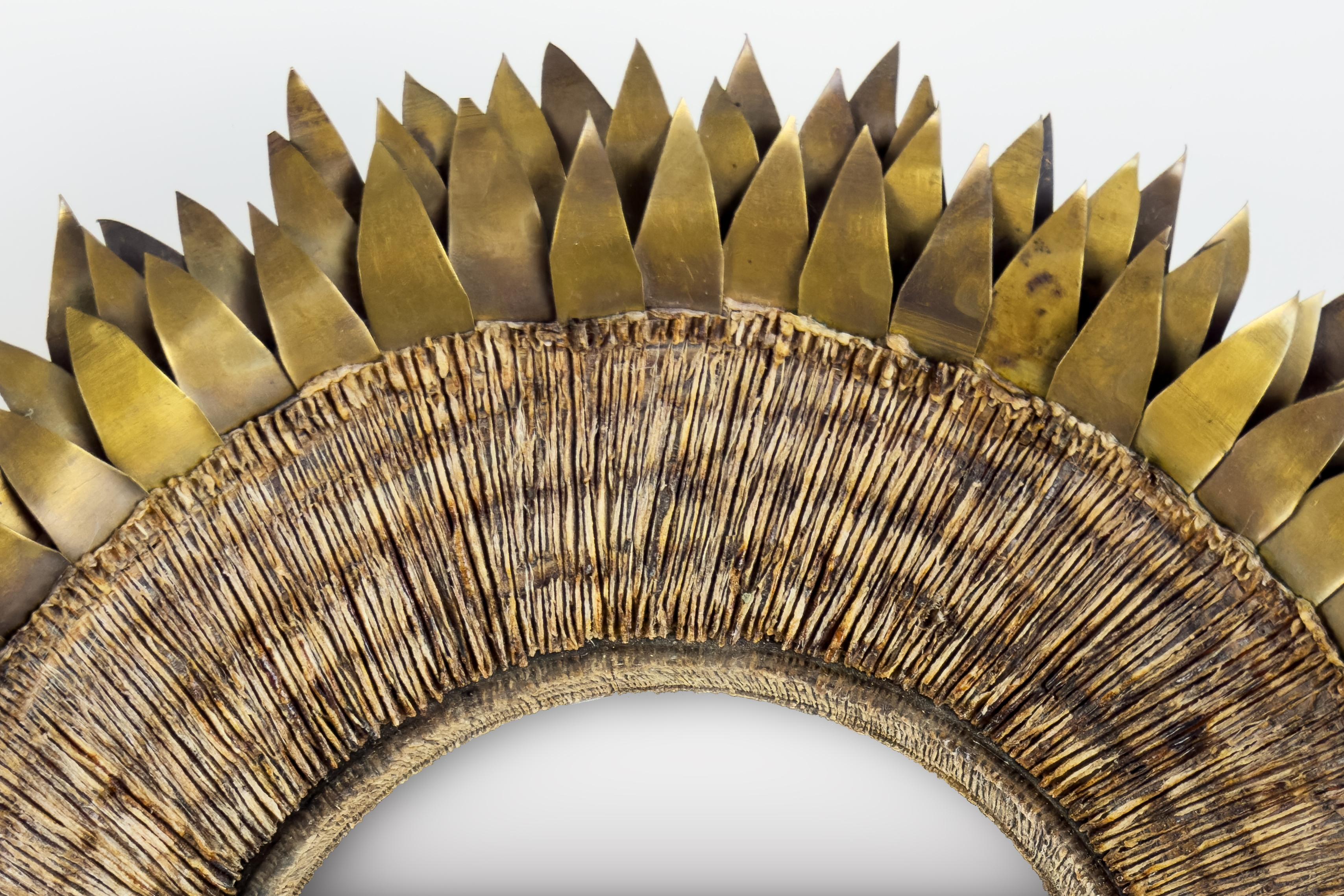 Questo splendido specchio circolare mette in mostra la maestria innovativa e l'eccellenza del design caratteristici della metà del XX secolo. Sebbene non sia firmato, lo specchio presenta una forte somiglianza visiva e materiale con opere attribuite