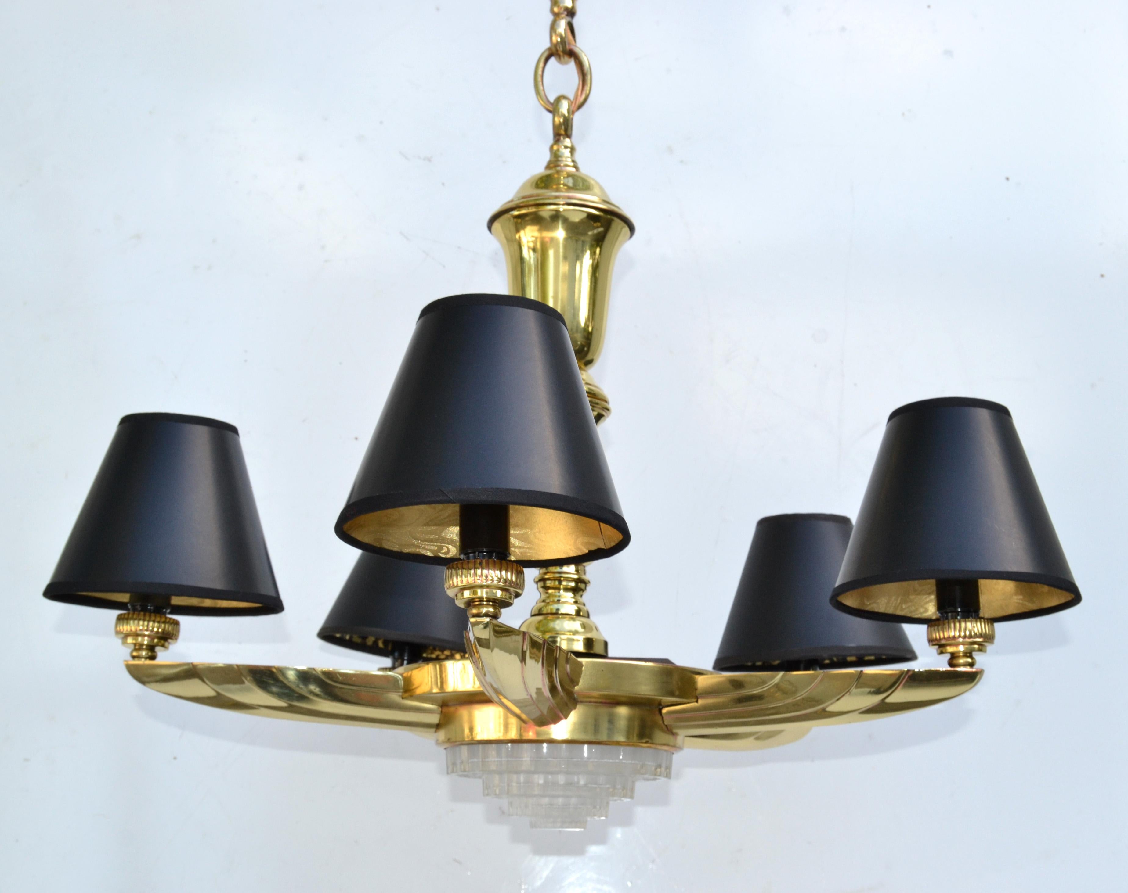 Atelier Petitot style French neoclassical round 6 light chandelier with black & gold clip on Paper Shades, made in the 1950.
Features 5 cast Bronze scalloped Arms holding a cut glass Centerpiece and fastened with Brass Modules as Stem.
Comes with