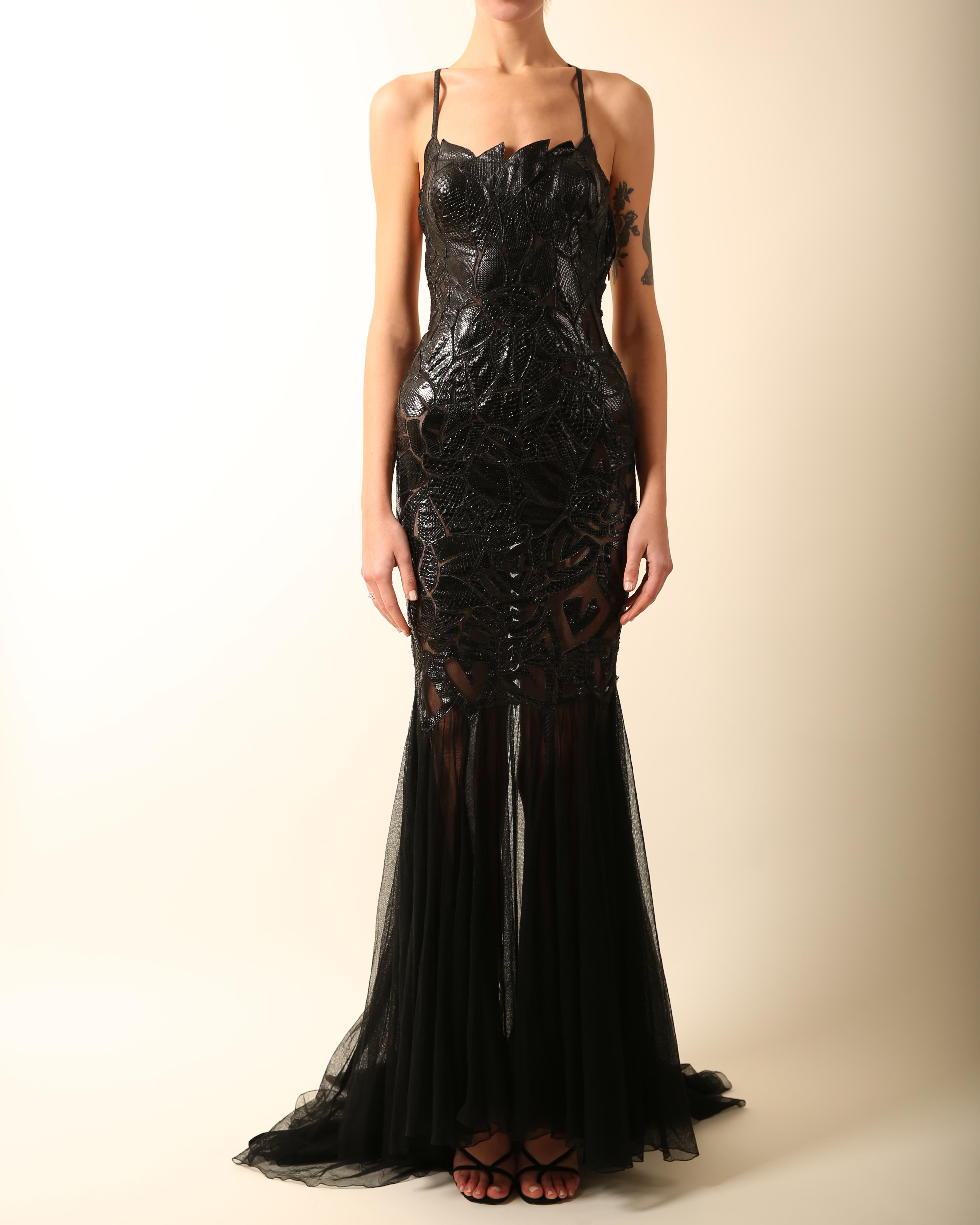 LOVE LALI Vintage

Atelier Versace
An absolutely breathtaking and incredibly rare gown in black cut out patent python and sheer mesh
Spaghetti straps that criss cross at the back doing up one side via a popper
A very low cut backless cut
Reinforced