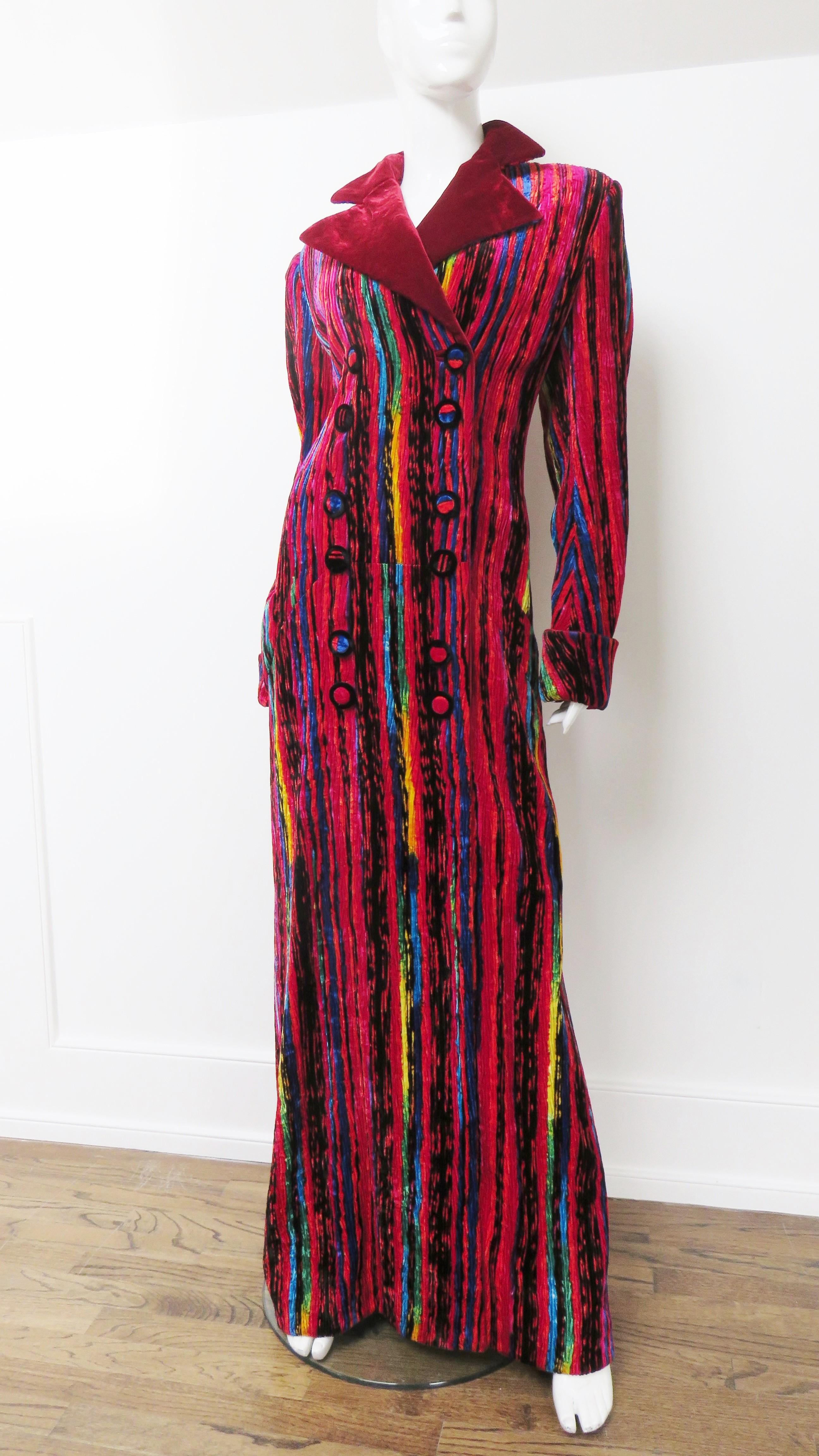 A fabulous full length silk velvet maxi jacket from Atelier Versace from Gianni Versace in red with brightly colored variegated vertical stripes in yellow, blue, green and black. The coat is double breasted with self covered front buttons and one on