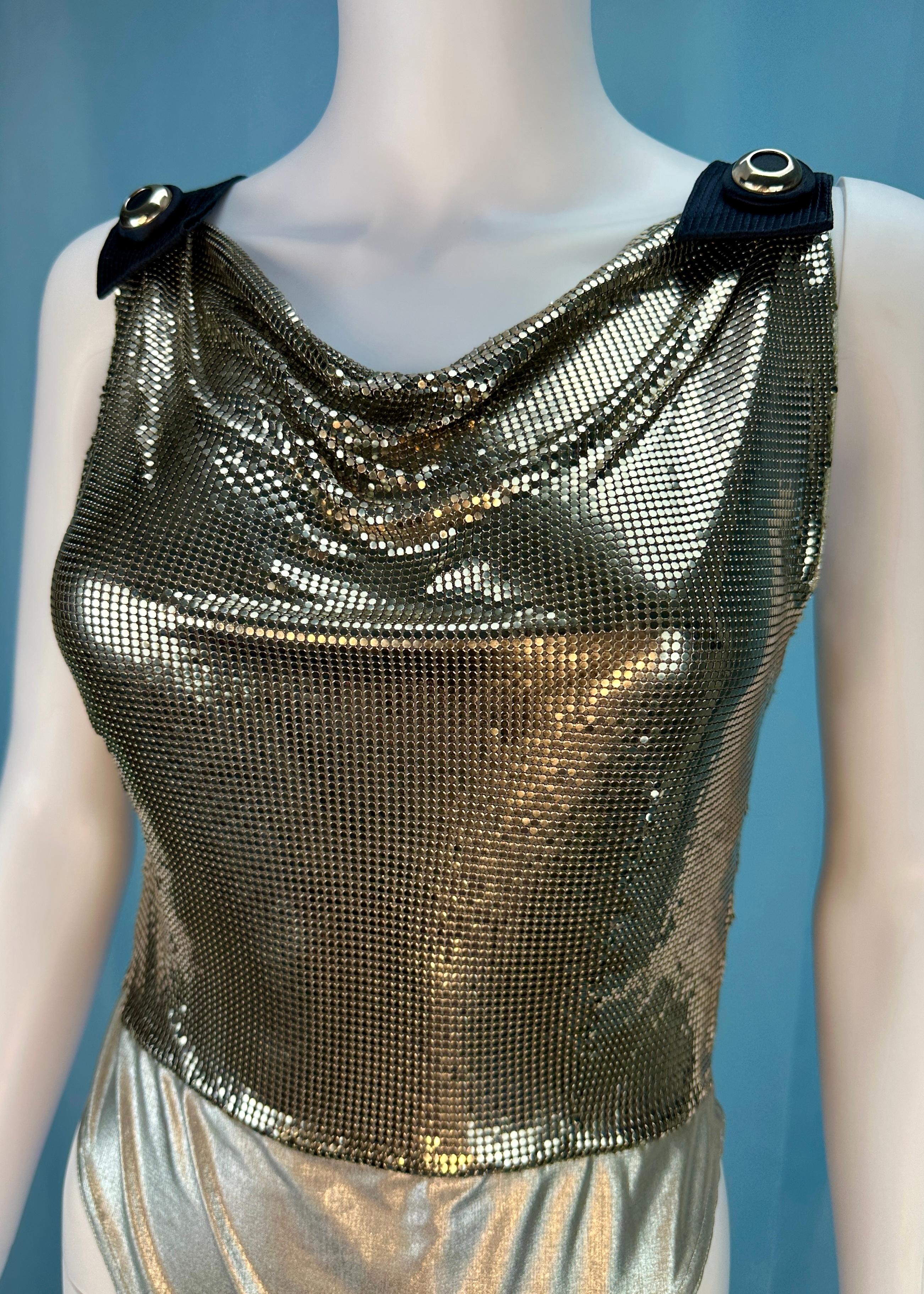 Atelier Versace 
Spring 1994
Atelier Versace - Versace’s haute couture made-to-order line 
Most likely a one of a kind piece

Silver tone metal Oroton chainmail bodysuit
Cowl neckline 
Stretch fabric section on lower body, with hook and eye bodysuit