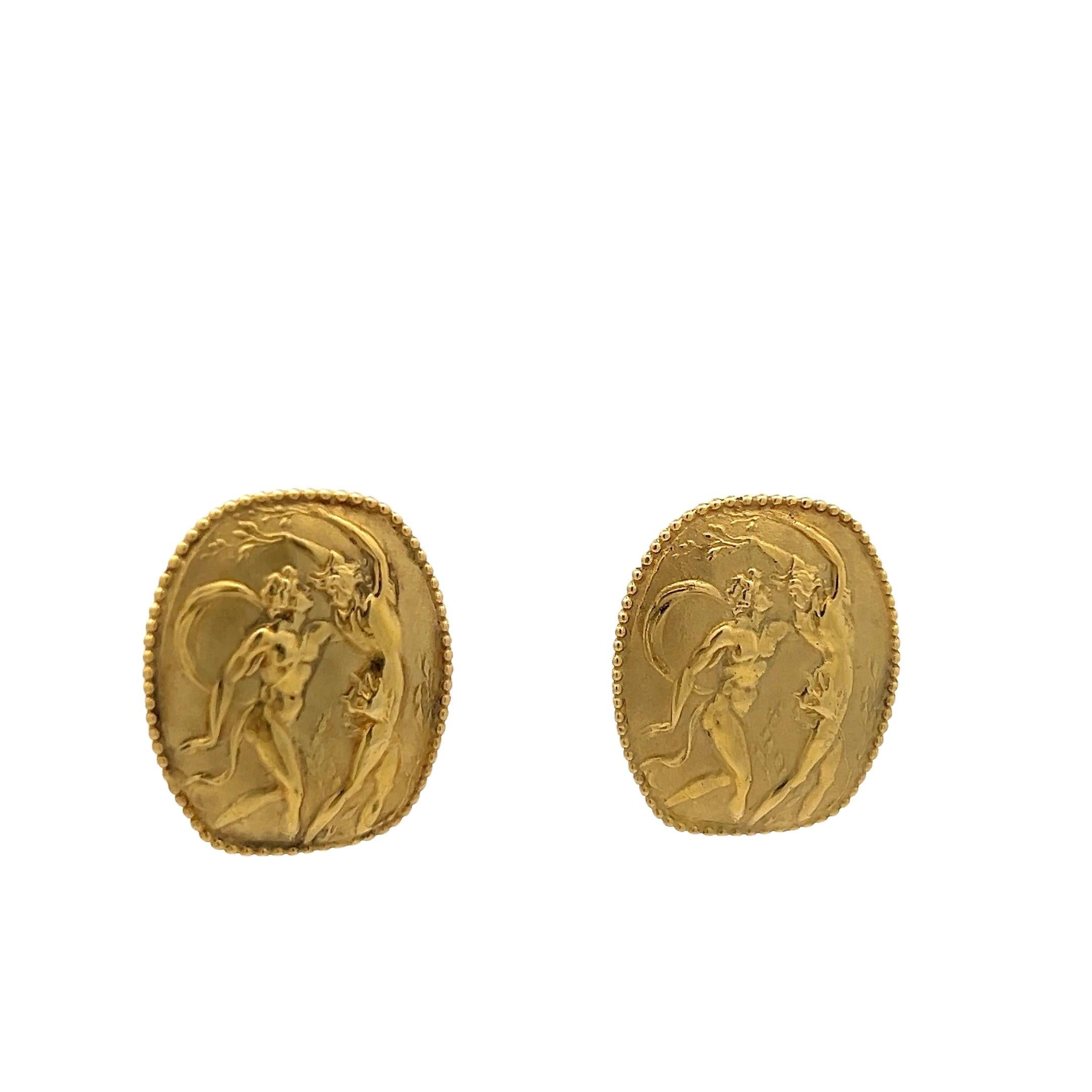 Cette paire de boucles d'oreilles en or jaune 18 carats, puissante et sculpturale, représente une scène mythologique centrée sur Athéna, la déesse grecque vénérée de la sagesse, de la stratégie et de la guerre héroïque. Réalisées en or jaune riche,