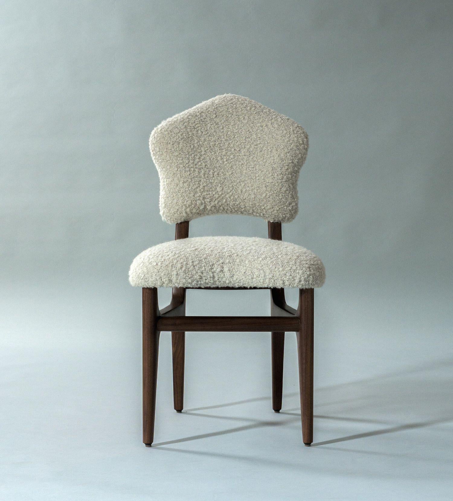 Der Athena Dining Chair ist eine kunstvolle Synthese aus Schönheit und Komfort. Er verbindet eine sanft gerundete Sitzfläche und Rückenlehne mit raffinierten, anmutig verjüngten Beinen aus Massivholz. Erhältlich in einer Reihe von