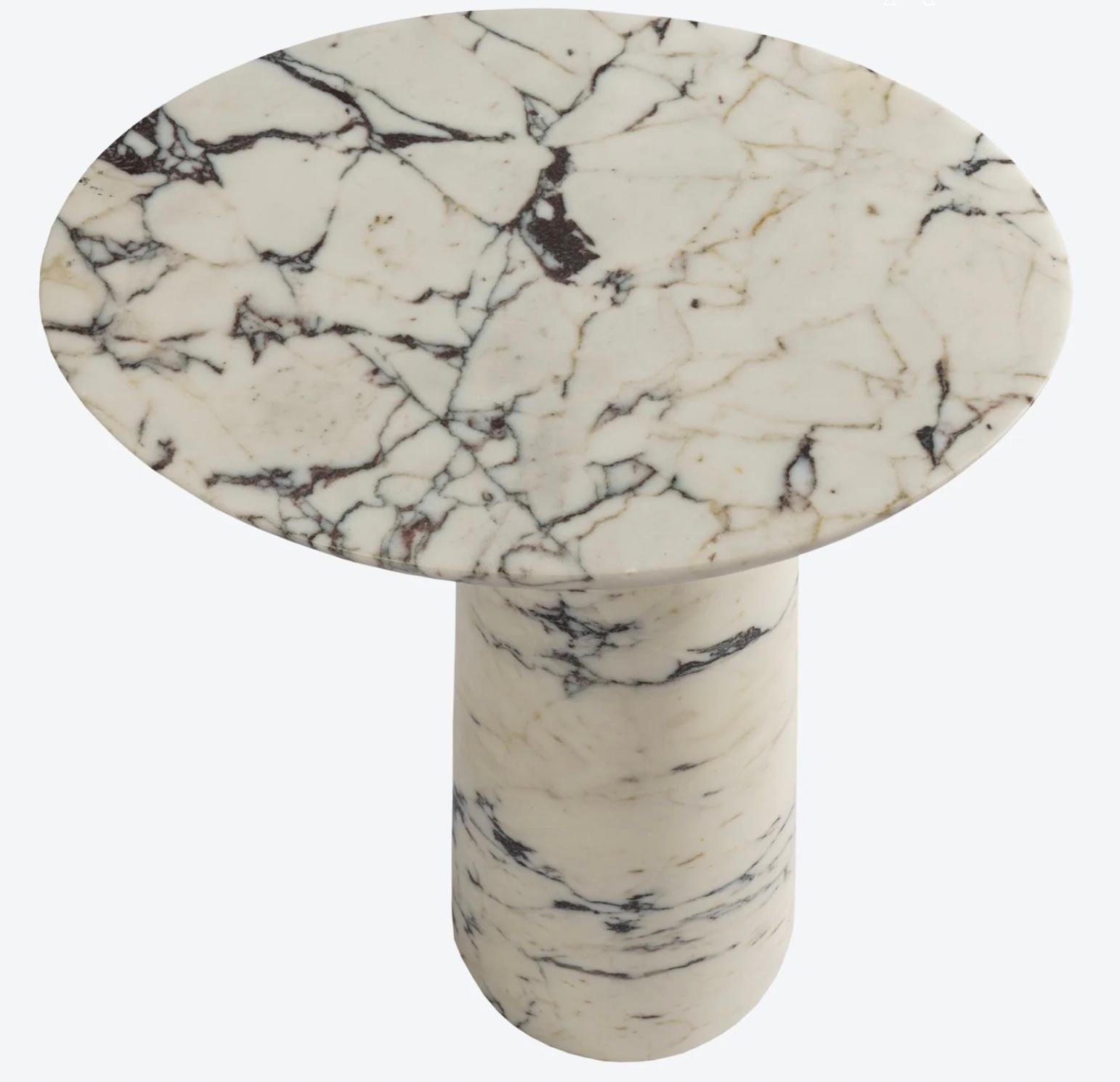 Our Athena table is comprised of crescent shaped table top elegantly perched on a conical pedestal. Deliberately asymmetrical. Carved from small blocks of Calacatta Viola marble. Due to the nature of the stone, each piece may vary.

Handmade in