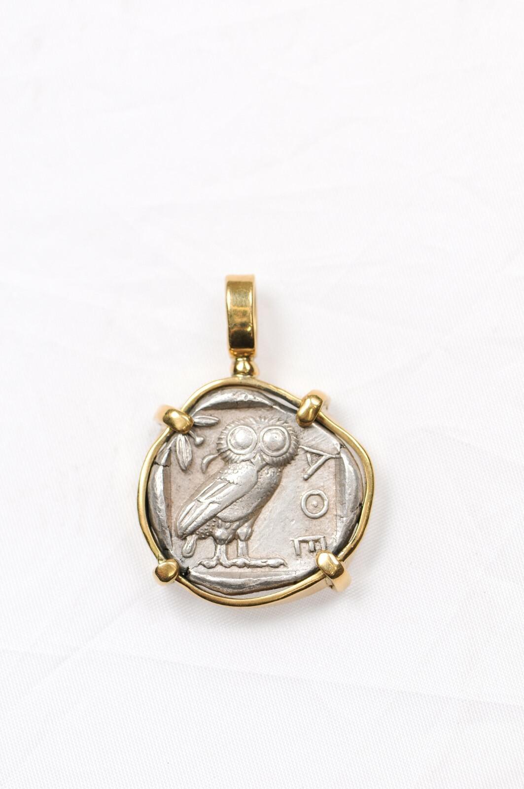 Questo spettacolare tetradramma con Atena e una civetta è decorato con oro a 18 carati e risale al 450 a.C. circa - coniato ad Atene. Sul dritto è raffigurata la testa di Atena, che indossa un orecchino circolare e un elmo con tre foglie di ulivo.