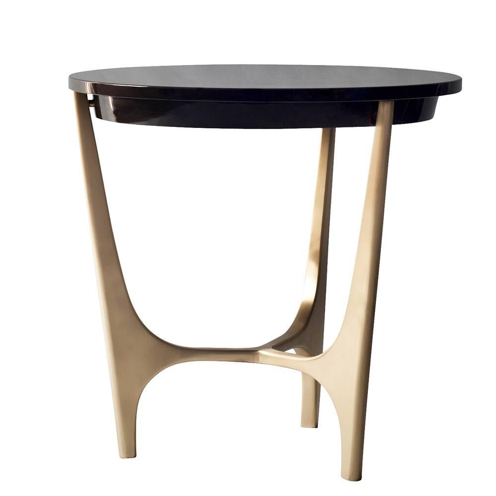 The Athena side or end table by DeMuro Das has a circular top in polished black Marquina marble supported by a sculptural, hand-cast solid Bronze base. The marble is mostly black with subtle white veining.