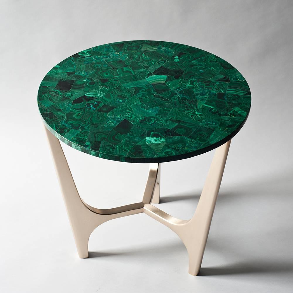 The Athena side or end table by DeMuro Das has a circular top in Malachite supported by a sculptural, hand-cast solid Bronze base. Malachite is a semi-precious stone with vivid green and black patterning.