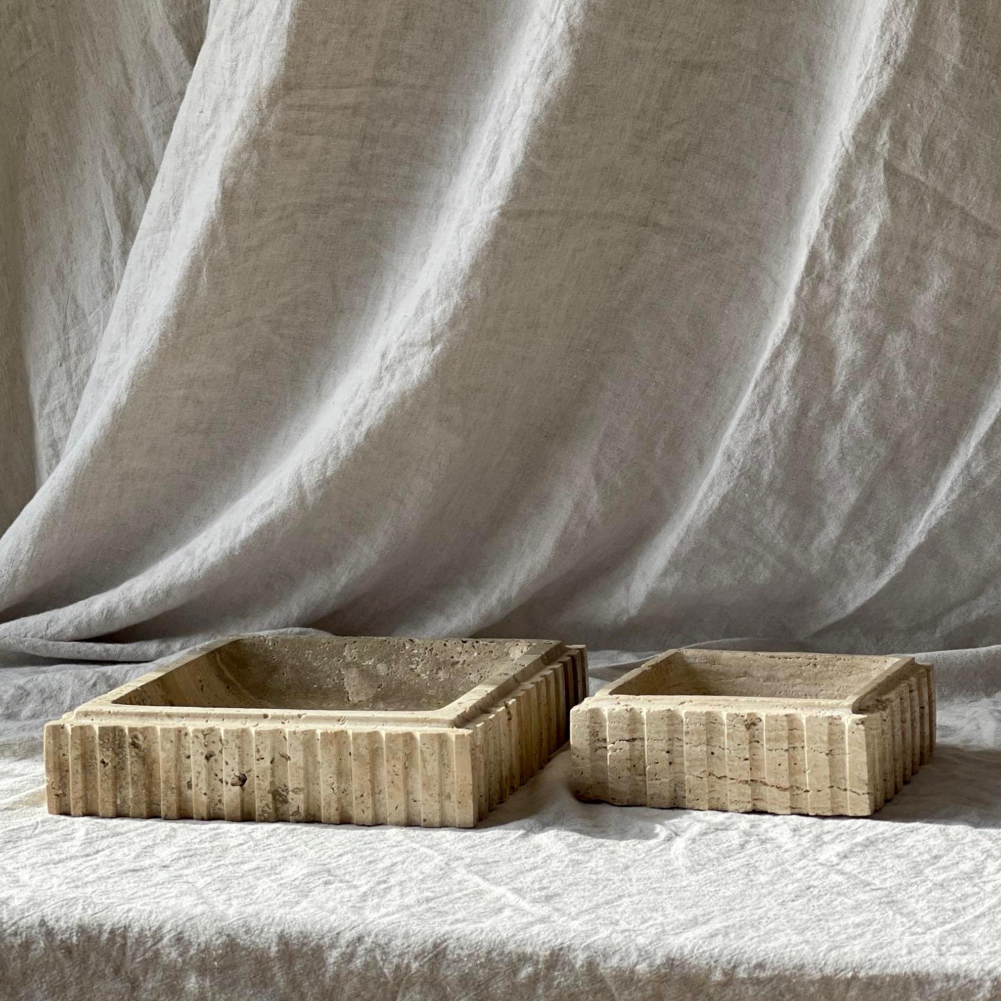 The Athens Catch is a limited production functional object d'art by Anastasio Home. 

Crafted from a single piece of solid stone, this substantial nine by nine inch square bowl showcases roughly fluted sides, meticulously hand-finished by skilled