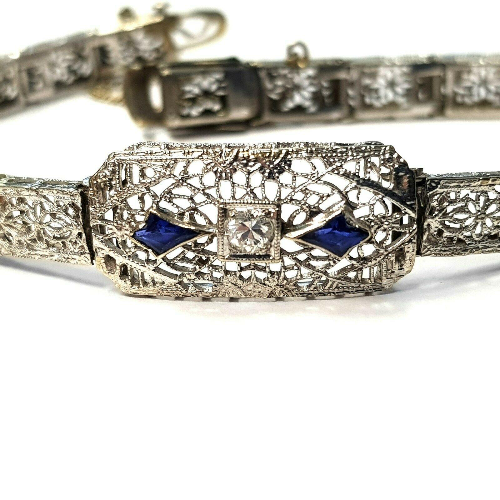 Art Deco Style 10k white gold bracelet with two kite shape sapphires and 0.10ct diamond. 
Specifications:
    main stone: KITE SAPPHIRES 0.30 ct/ 2 PCS
    additional: DIAMOND
    diamonds: 1 PCS
    carat total weight: 0.10
    color: H
   