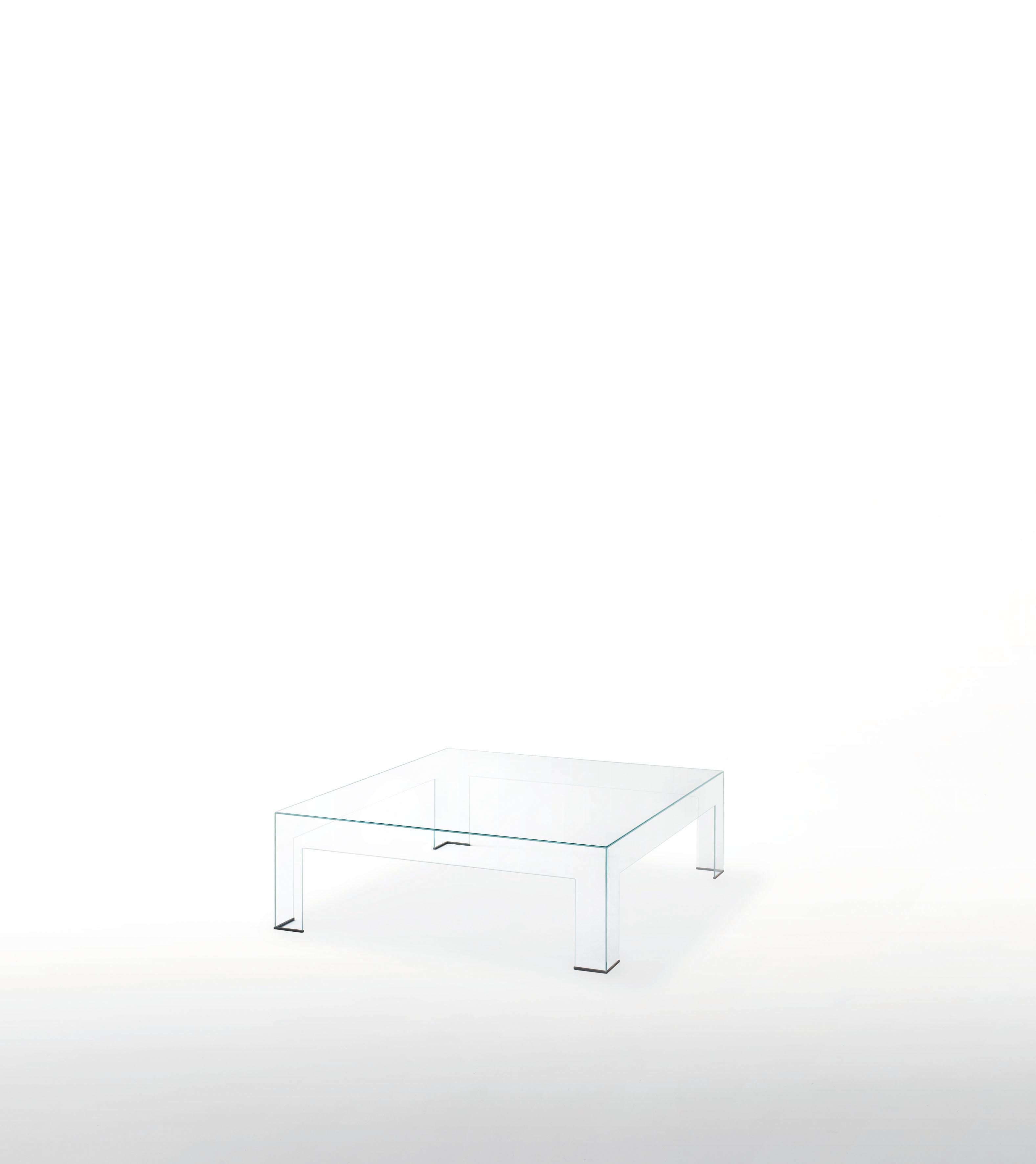 High table obtained by glued 8 mm. thick tempered glass plates, cut with water jet and with 45° chamfered edge. Available in extra light transparent glass. The formal purity, the sobriety and the sophisticated craftsmanship are the main features of