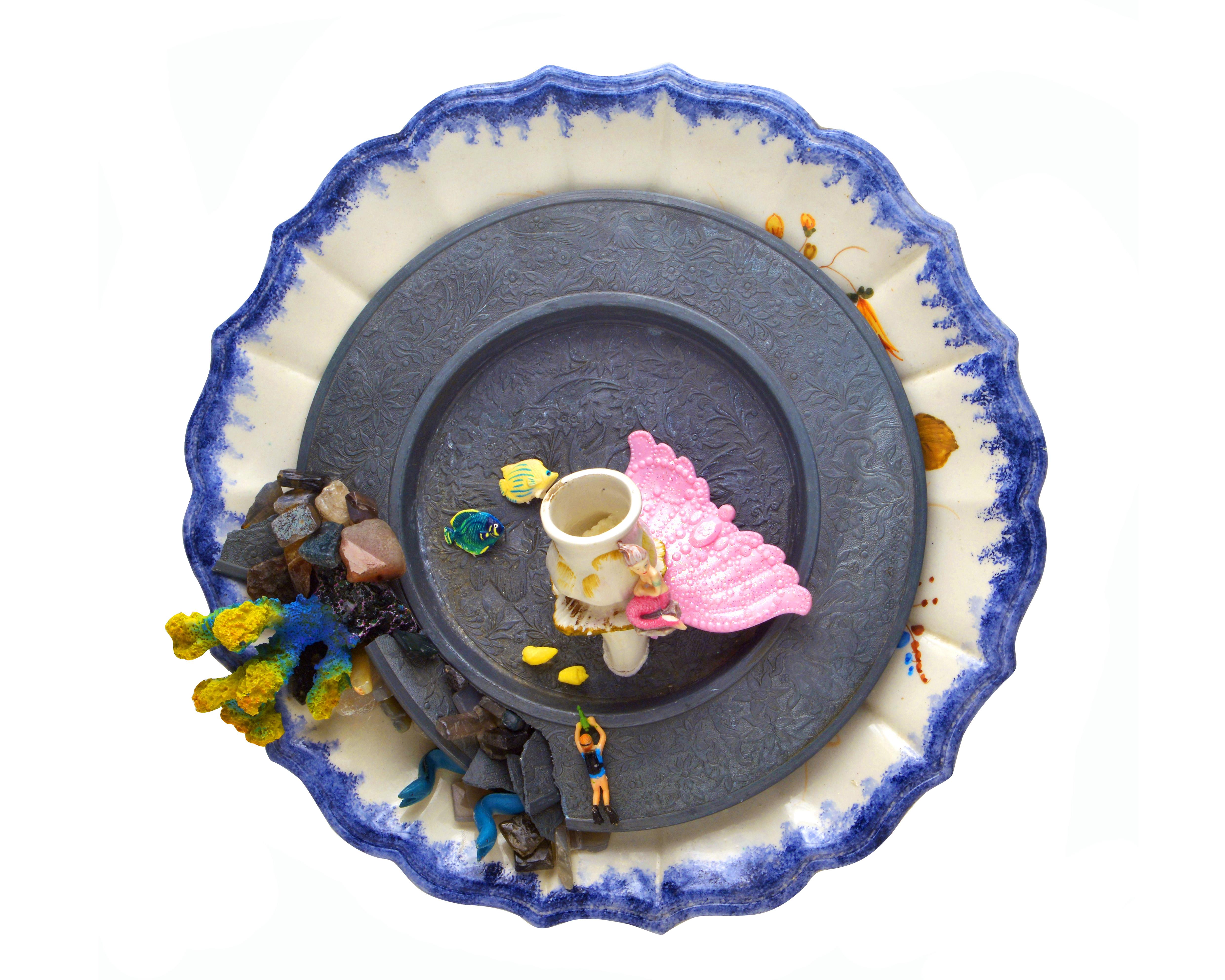 Composition réalisée avec :
Grande assiette décorative  céramique blanche  avec une bordure bleue.
Fabrication : Portile
Petit plat décoratif en étain.
Fabrication : Berendsolun
Portion de bougeoir en céramique.
Fabrication : Bassano
Jouets en