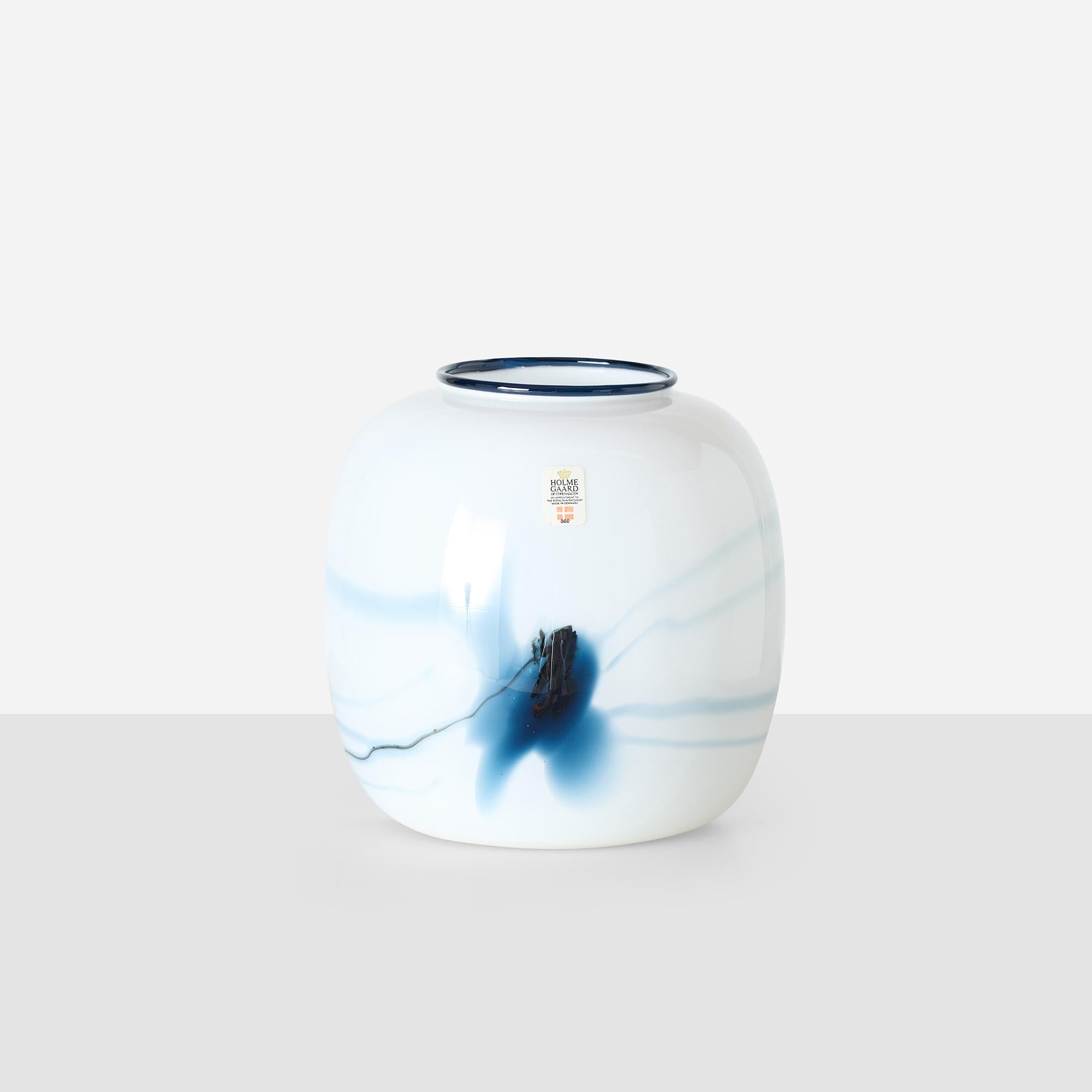 Vetro bianco incamiciato con decorazione interna blu inchiostro e bordo nero, disegnato da Michael Bang per la linea Atlantis di Holmegaard. Etichetta originale. Condizioni vintage molto buone; leggera irregolarità naturale del bordo dovuta alla