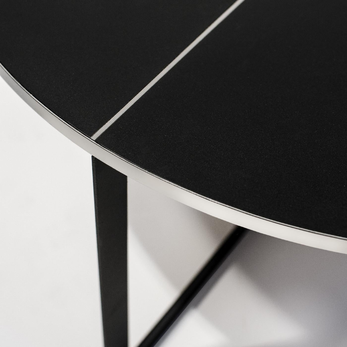 Cette superbe table basse est un choix audacieux et raffiné pour un salon contemporain ou industriel. Sa structure géométrique comprend quatre pieds qui se croisent à la base et soutiennent un plateau rond et lisse. La pièce est entièrement
