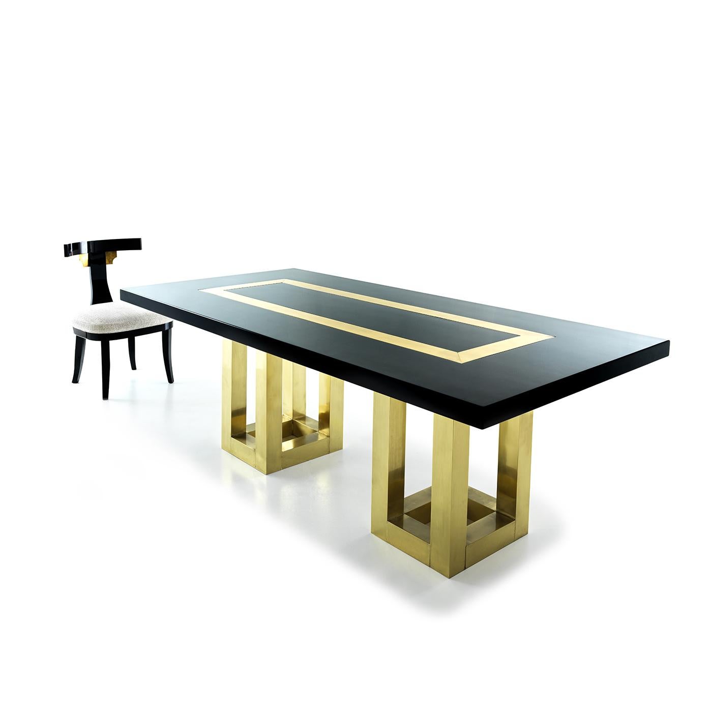 Der Tisch Atlas ist ein ausgefallenes Stück, das aus einer eleganten, schwarz lackierten Holzplatte mit Messingintarsien besteht, die von einem Paar lackierter Beine aus natürlichem Messing getragen wird. Es handelt sich um ein wirklich