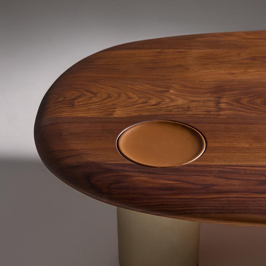 A sculptural piece that embodies both strength and elegance.
Crafted from solid walnut, Atmos Grande features a carefully integrated leather tray — a subtle gesture that evokes human touch and presence. Its anodized aluminum legs in a bronze finish
