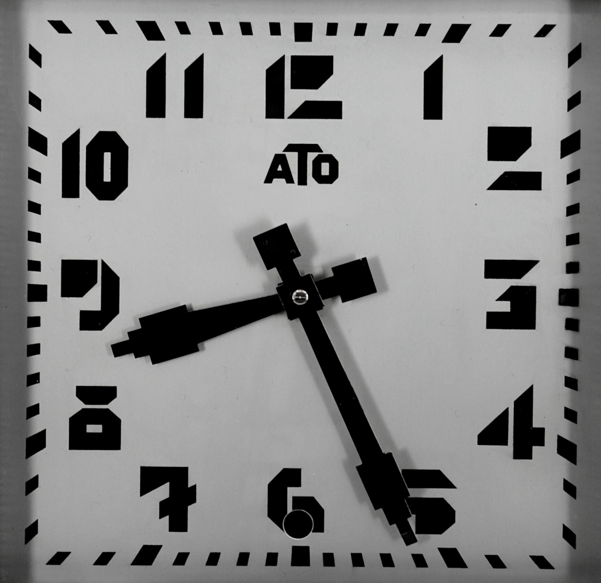 Horloge murale française Art Deco par ATO (Paris), France, vers 1930. Bois et métal. Le cadre est en bois et imite le métal. Vis de réglage externe d'origine. Dimensions : Hauteur 42 cm, largeur 42 cm, profondeur 7,5 cm. Marqué 