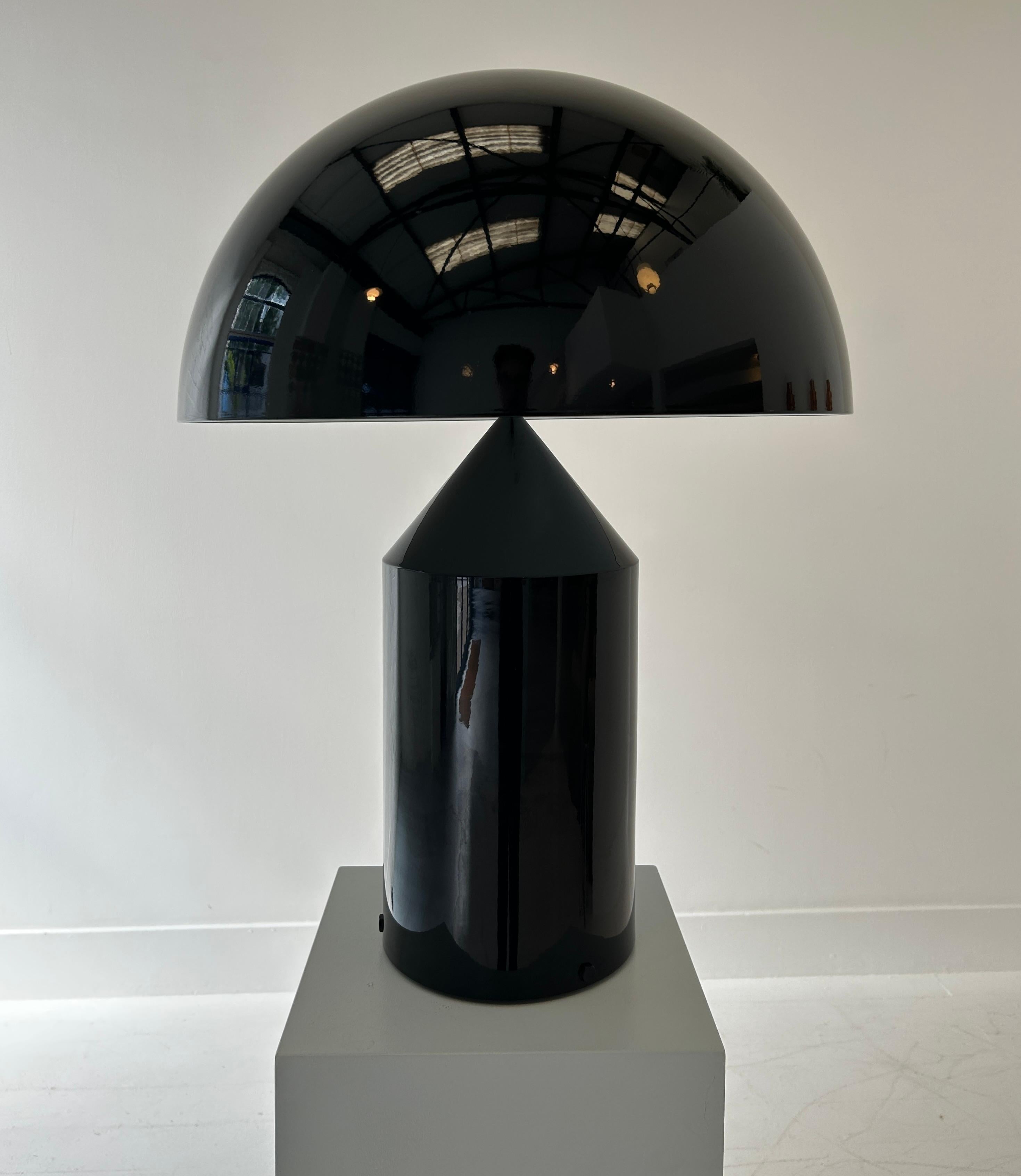 The archetypal table lamp, this is an example of an early edition of the Atollo lamp, finished in high gloss black aluminium. 

The classic design is known universally for its simplistic elegance, and its robust utility. Conceived originally in 1977