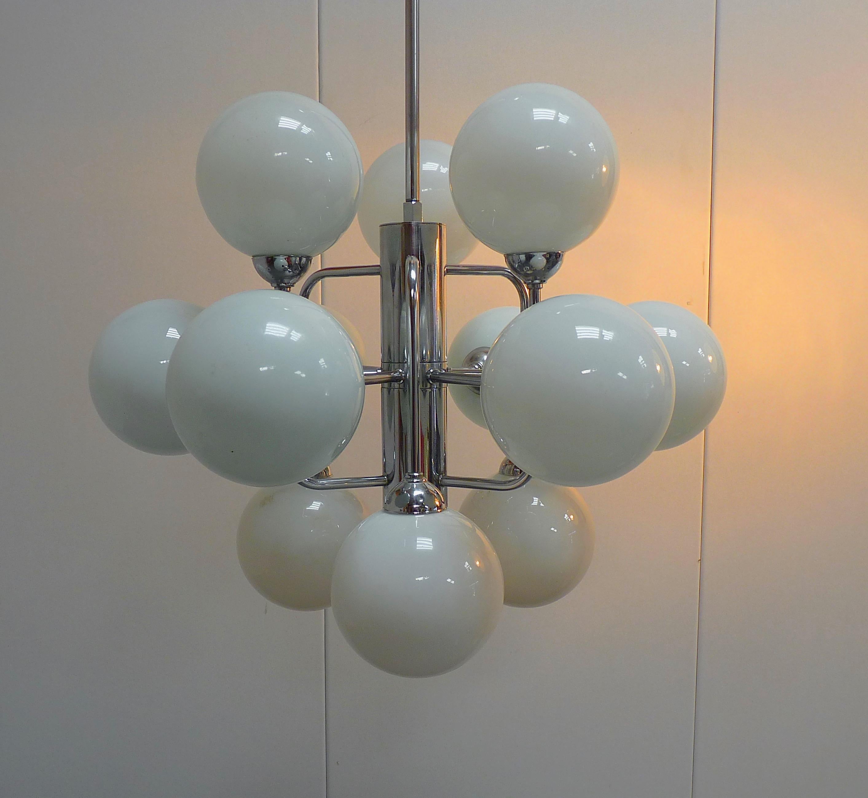 Large chrome and opaline globe atomic chandelier. The atomic globe chandelier exists in many forms and sizes.
This atomic chandelier has many similarities with the globe lamps designed by Eva Renée Nele Bode (E.R.Nele) for Temde Leuchten, Germany,