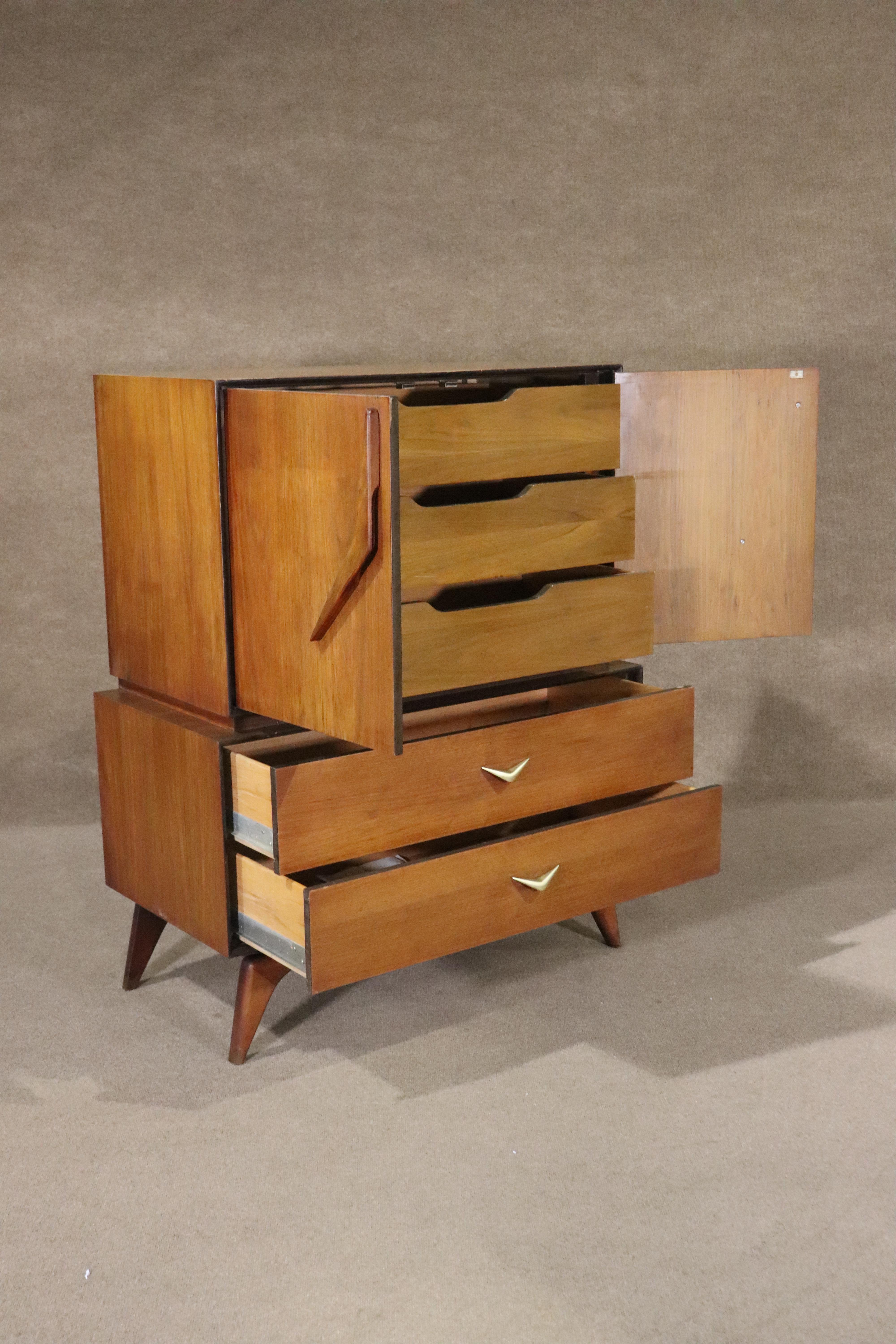 Mid-century modern tall chest of drawer with sculpted base and matching boomerang handles. Five wide drawers in a cabinet that floats above the wood base.
Please confirm location NY or NJ