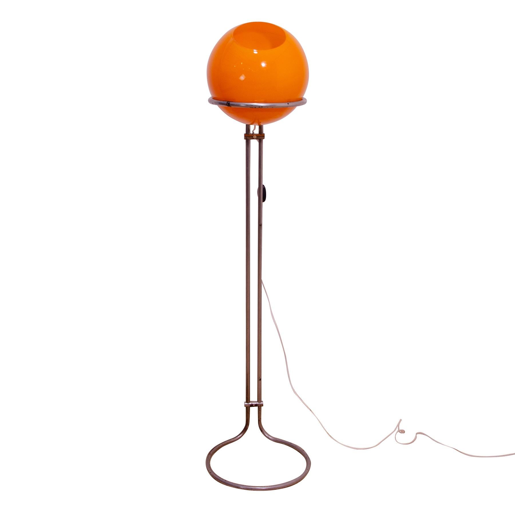 This atomic age floor lamp was designed in 1973 by Hungarian designer Tibor Hazi and made in Hungary in the 1970s.

The lamp is made of orange opaque glass with a matte surface and and a chrome construction.
The rounded shape of the lamp is related